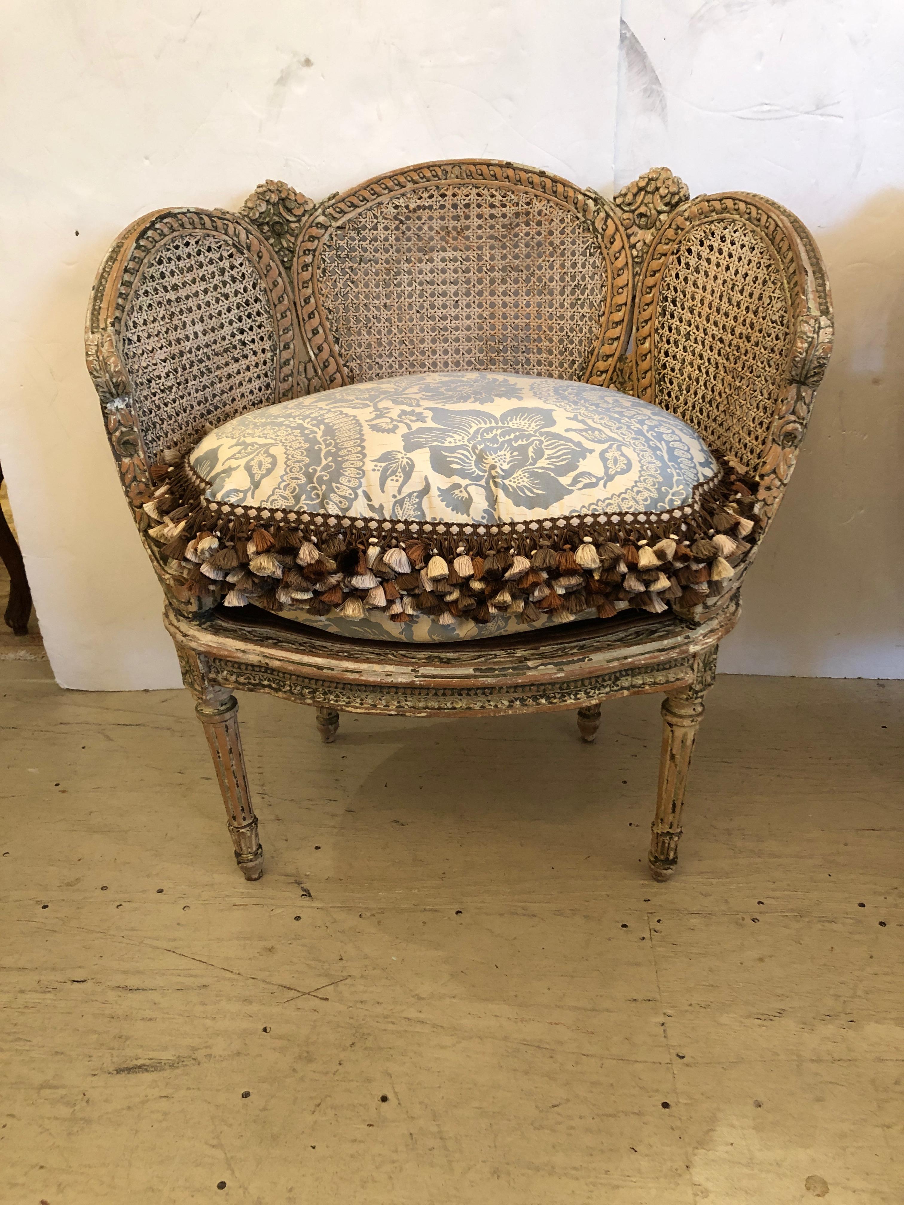 Two of the prettiest French antique boudoir chairs ever, having a natural chippy painted patina with raw wood, white paint and some pastel color visible. The sides are double caned, back is single caned, and while left in original condition, they