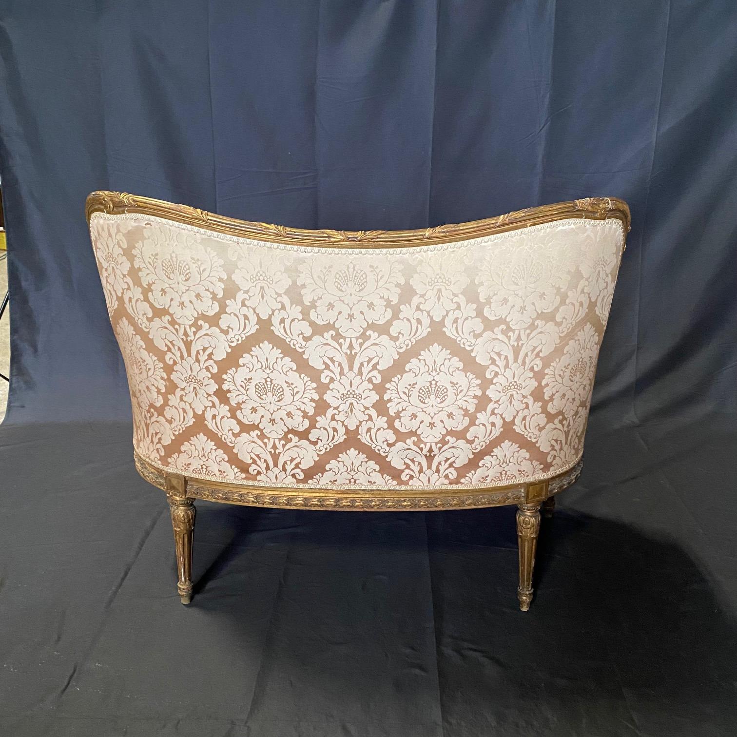Exquisite gilt wood carved French Louis XVI style sofa from a complete Parlor Suite, with elegant Louis XVI lines and delicate hand carved decoration, with great attention to detail having graceful curves, ornate carvings, and delicate floral