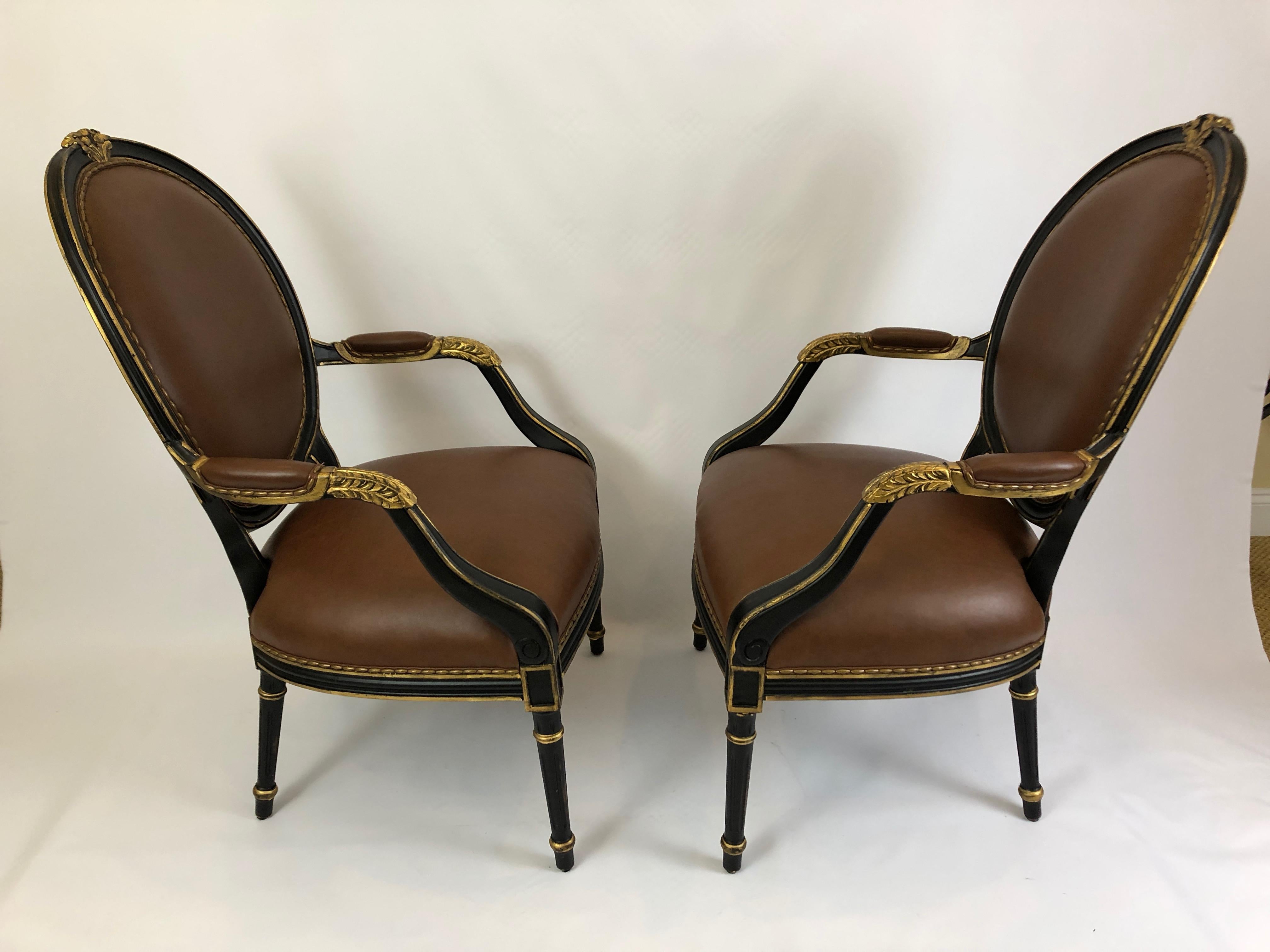 Impressive glamorous pair of roomy brown leather arm chairs having regal ebonized and gilded frames. The backs are oval shaped and beautiful front and back.
Measures: Arm height 28
Seat depth 21.