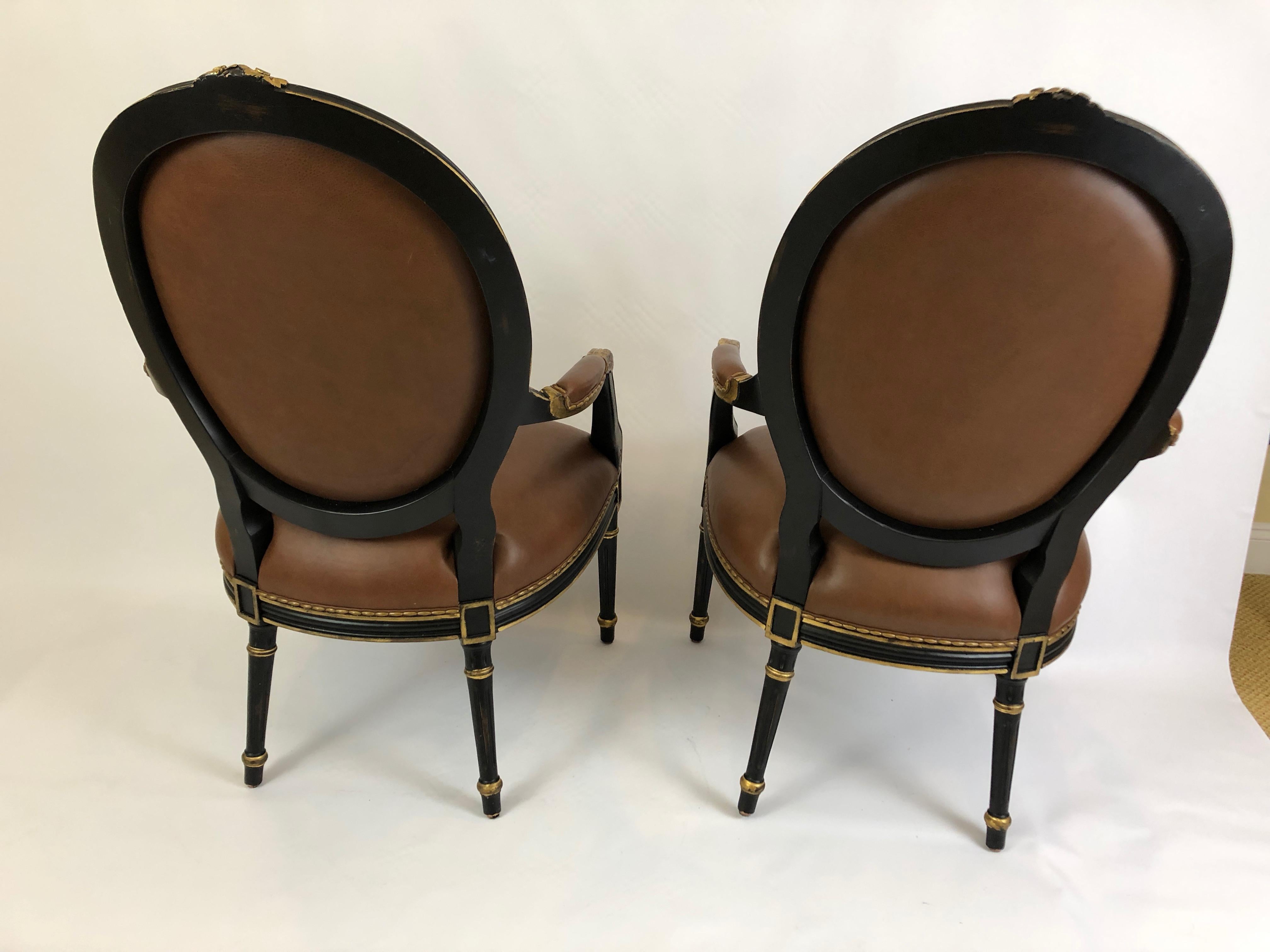 Hollywood Regency Century Pair of Supple Brown Leather and Ebonized Gilded Armchairs  For Sale