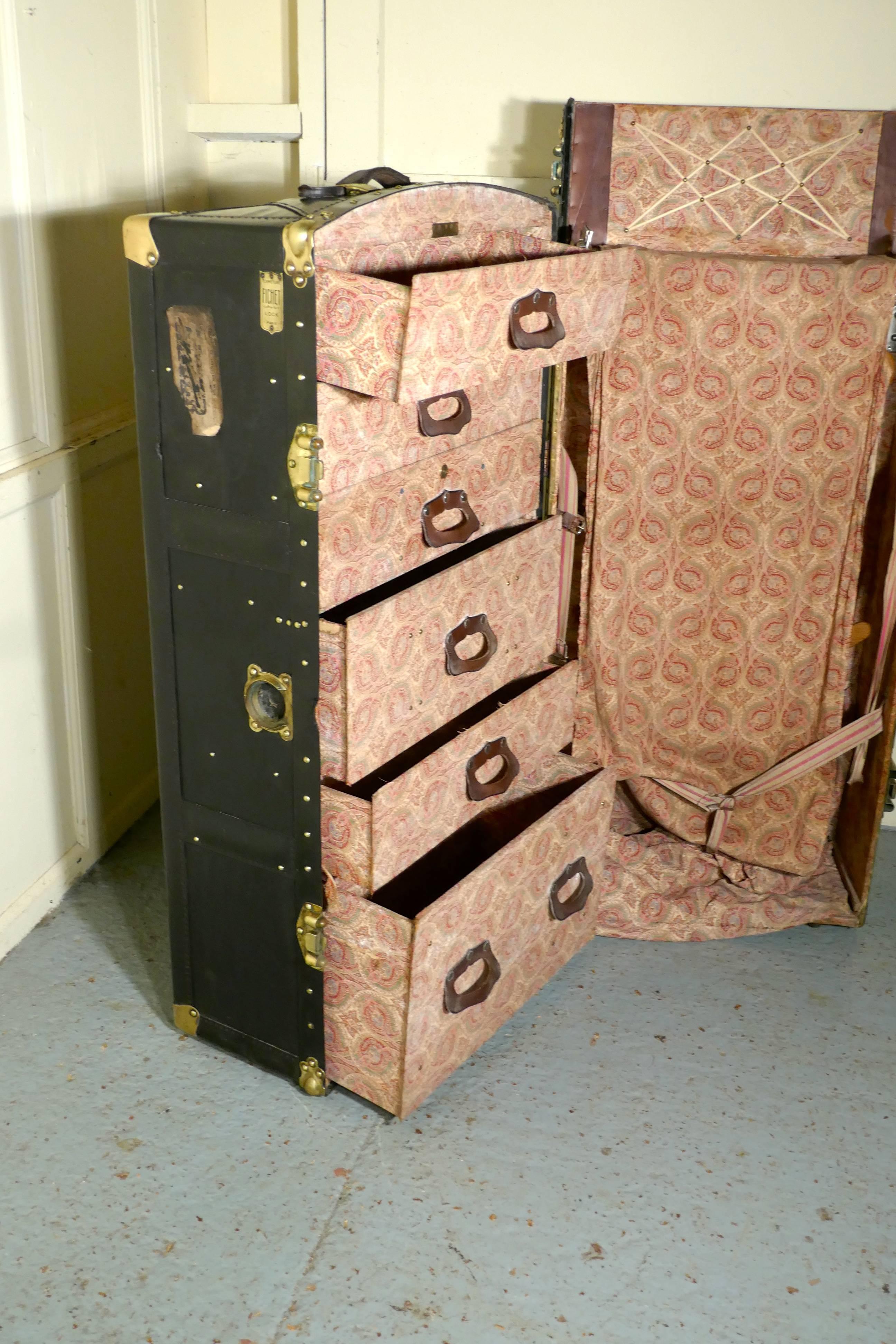 Fitted steamer trunk or cabin wardrobe, Portmanteau by Fichet

A superb piece of history dating back to the time when your luggage would be taken to your cabin. This one is leather, brass bound studded and it is domed at the top
The trunk opens