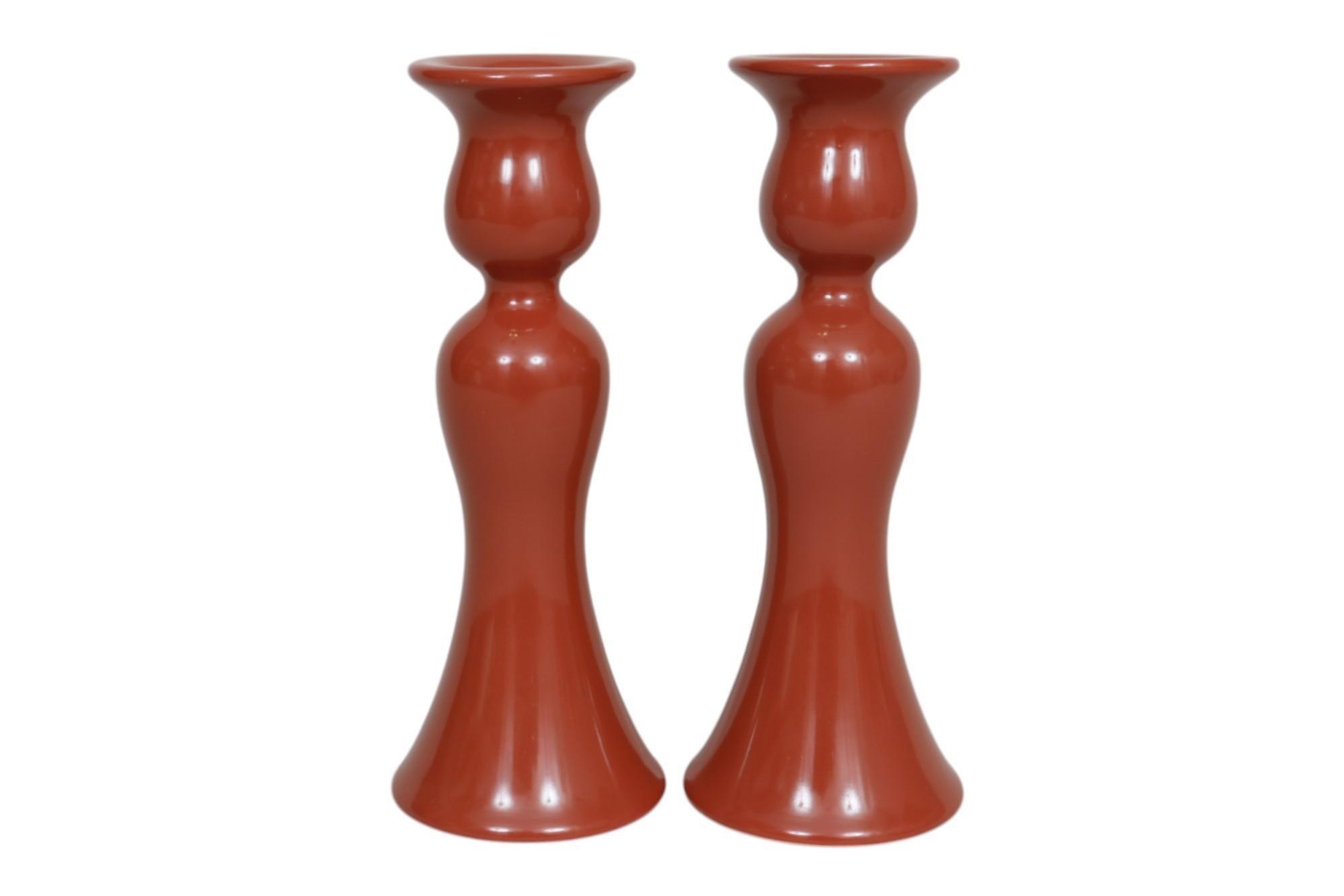 Coppia di portacandele in ceramica Fitz and Floyd in rosso cinabro, realizzati in Giappone. A forma di tulipano, con capitelli e colonne sinuose. Le ampie appliques rispecchiano l'andamento delle colonne alla base. Con la dicitura copyright Fitz and