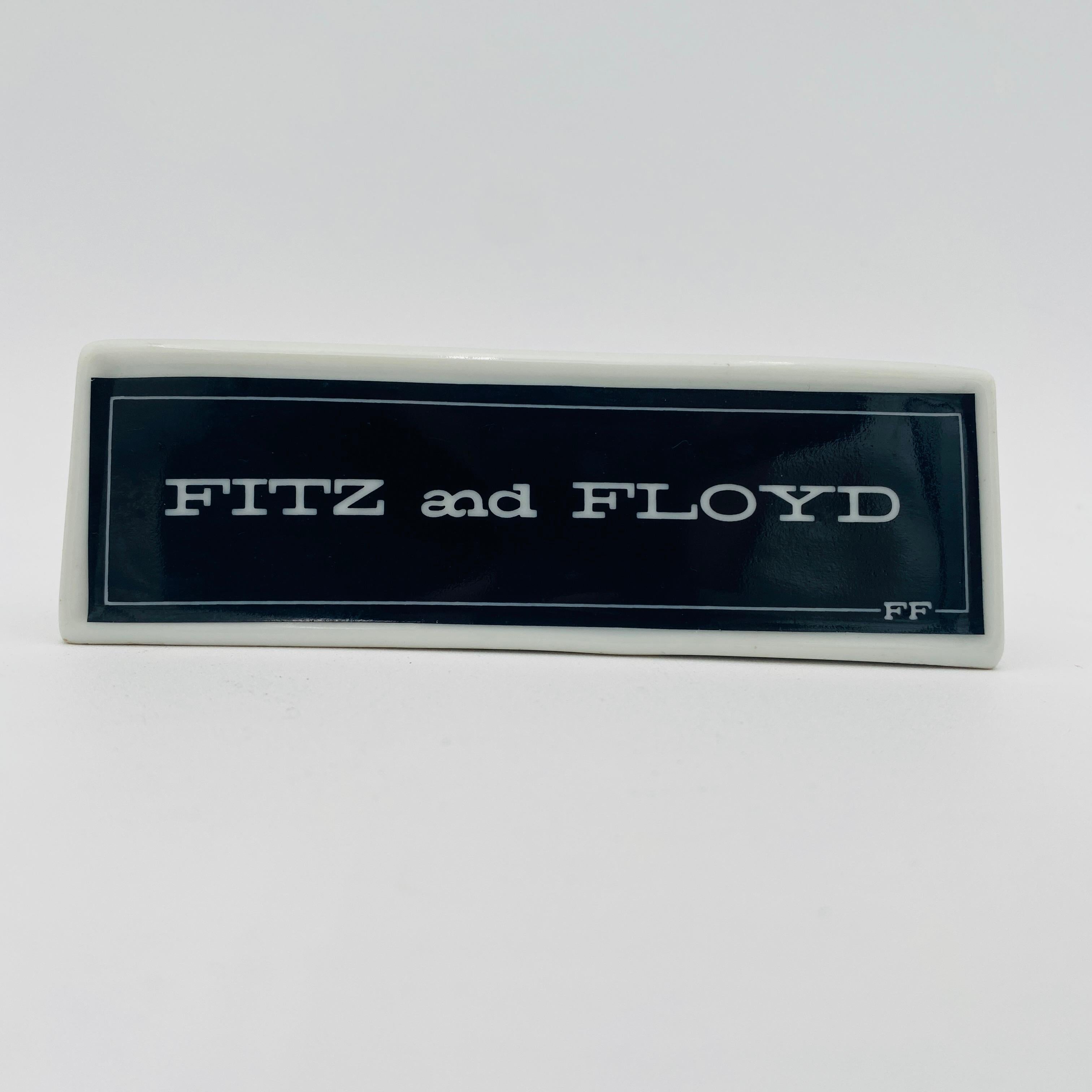 Si tratta di un'insegna da banco in porcellana a doppia faccia di Fitz and Floyd. Si tratta di un disegno in bianco e nero con il testo 
