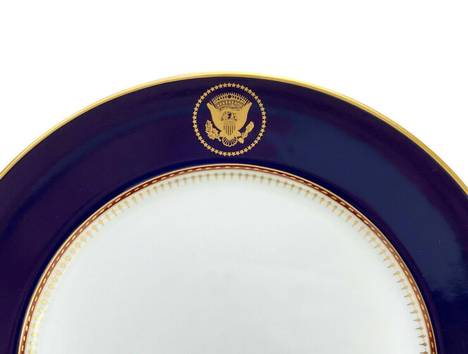Assiette de la Maison Blanche de Fitz et Floyd Reagan, 1983

Un fond bleu cobalt et le Grand Sceau des États-Unis doré sur les bords centraux supérieurs. Accents dorés sur les bords et le bord intérieur avec un motif piqué, pointillé et géométrique.