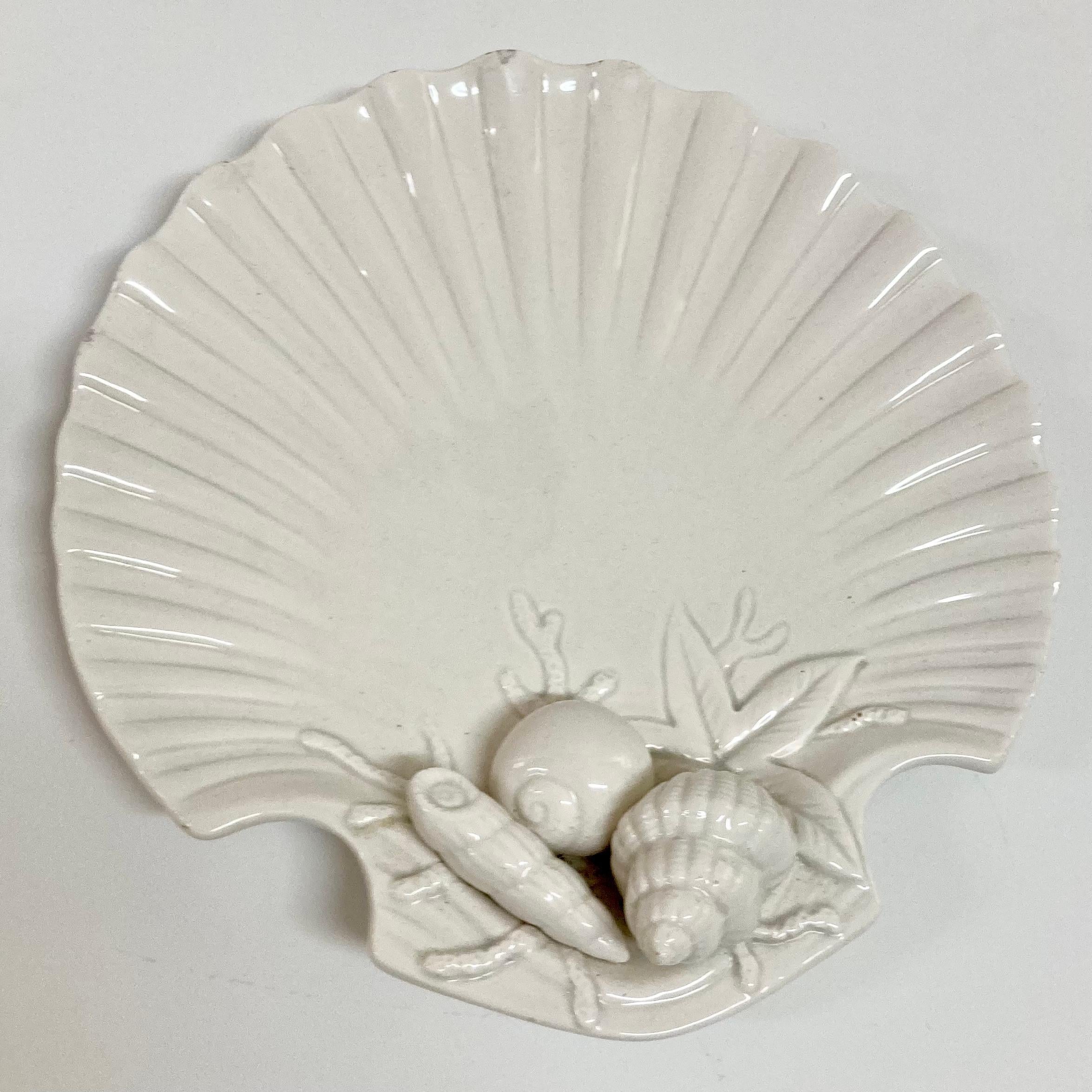 Piatto in conchiglia di Fitz and Floyd con dettagli in rilievo alla base. Bellissimo lavoro di dettaglio e texture. Una bella e semplice finitura in ceramica smaltata bianca. Aggiungi un po' di stile classico costiero al tuo orlo o al tuo progetto