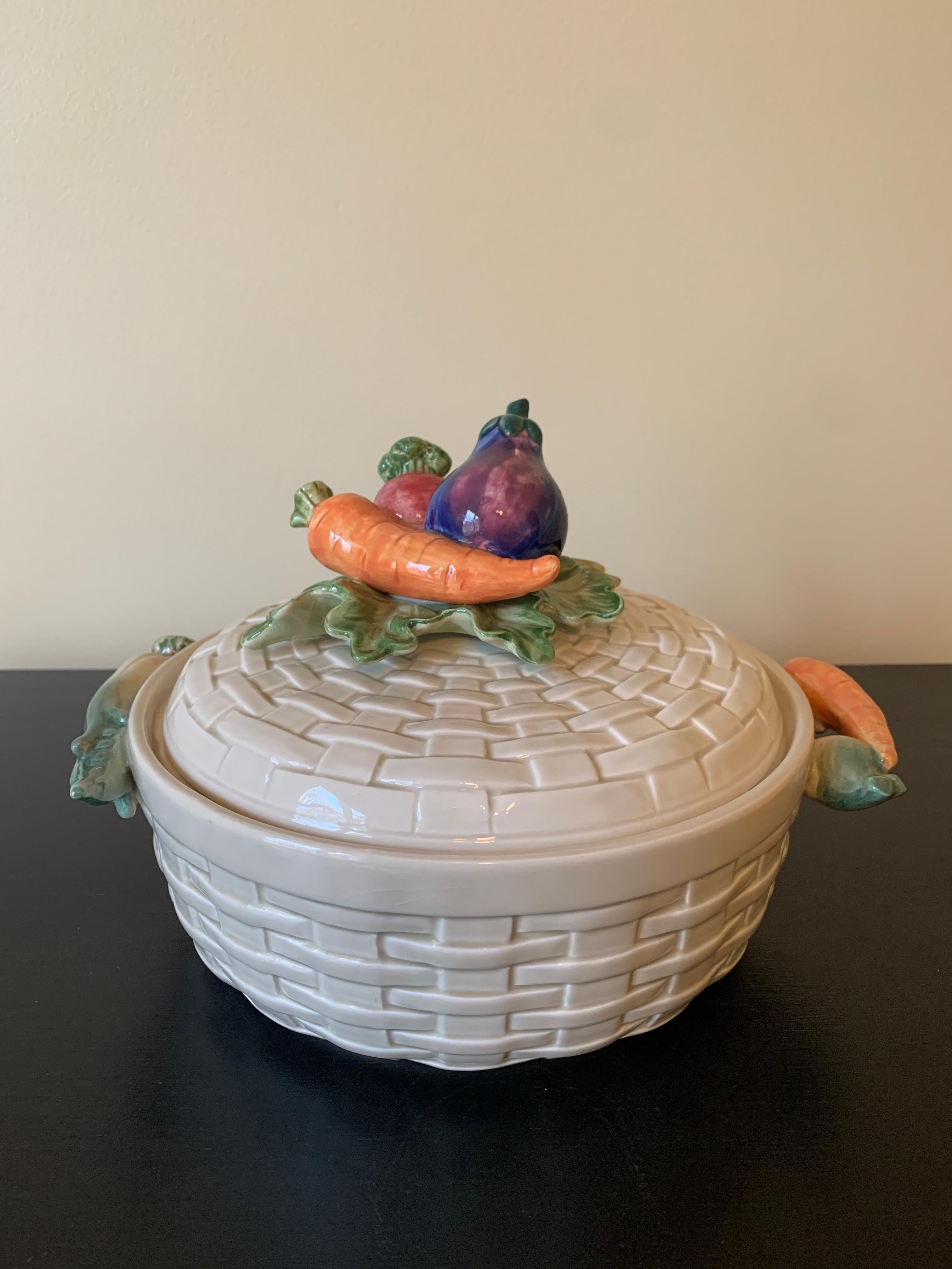 A stunning and rare majolica ceramic trompe l'Oeil covered dish or casserole in the form of a woven basket with various vegetables as the handles and on the lid.

By Fitz & Floyd

Circa 1980s

Measures: 10.75