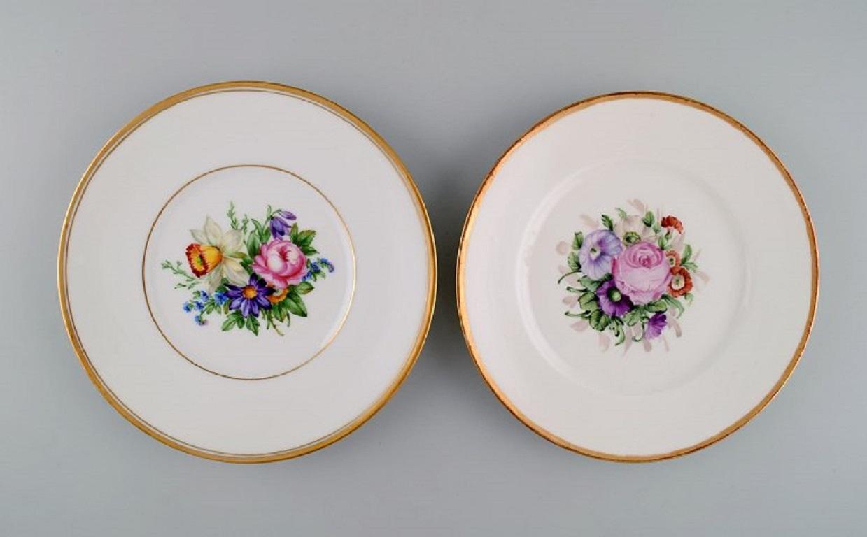 Five antique Royal Copenhagen porcelain plates with hand-painted flowers, insects and a gold border. 
Late 19th century.
Diameter: 19.7 cm.
In excellent condition.
Stamped.
1st factory quality.