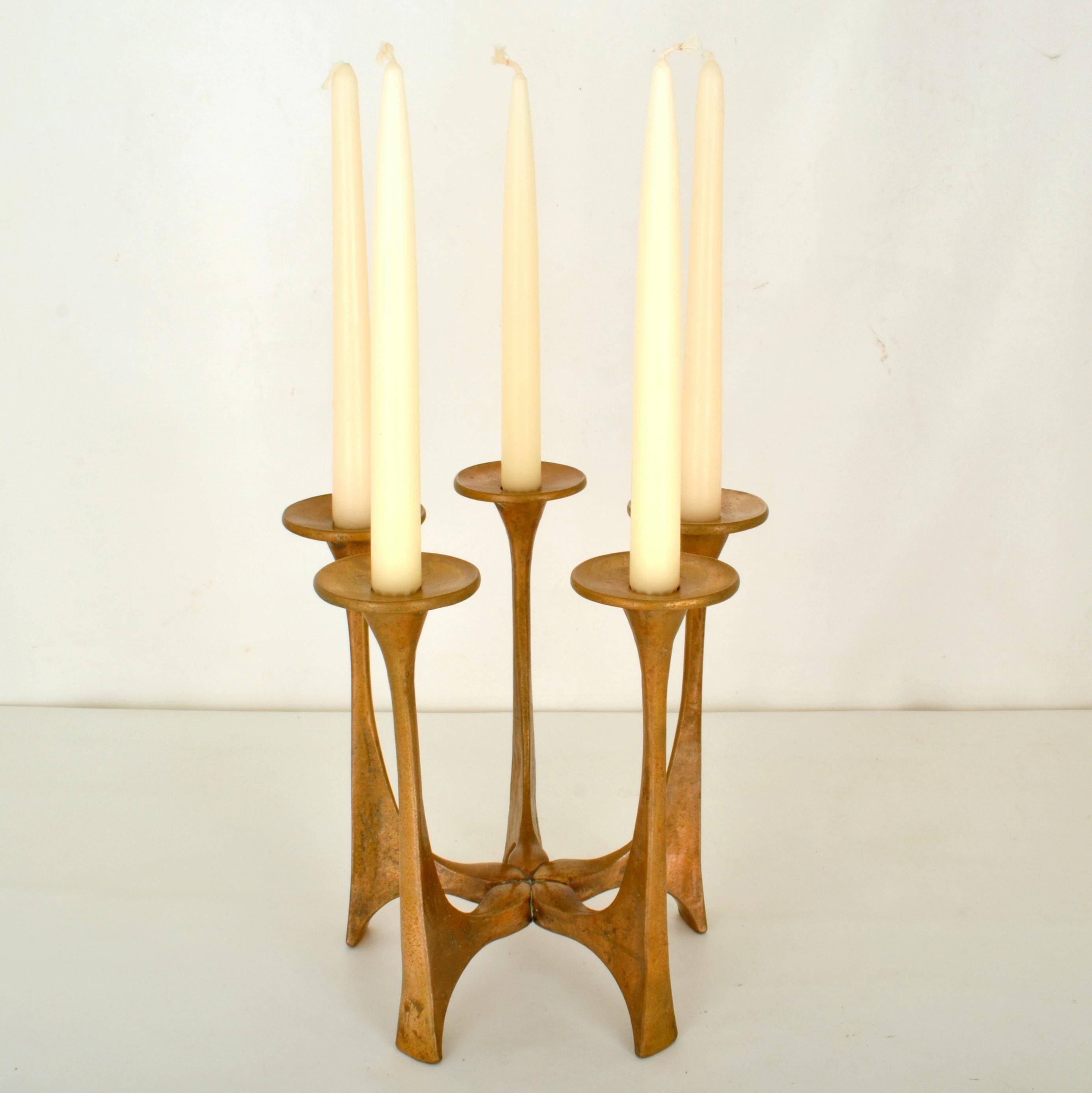 Bronze cast candelabra composed of five radiating cast-bronze arms with saucer shaped candle holders for regular candles. It is designed by Michael Harjes (1926-2006) and produced by Harjes Metalkunst (1912), the family business in Germany. The