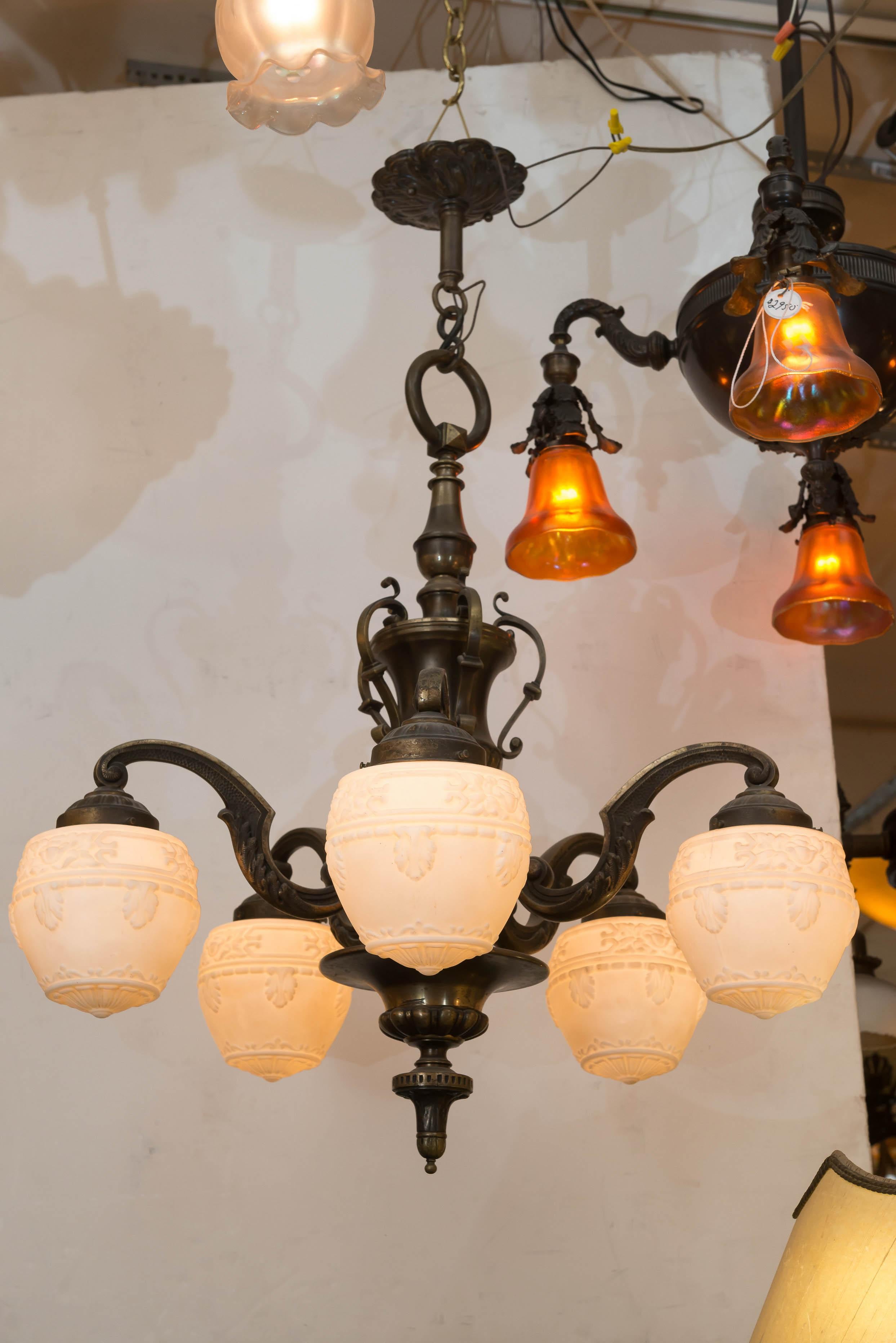   Not much more that we can say here that our title has said. This nice period chunky bronze chandelier has 5 of the most popular choice glass shades, white acorns shades. Acorn is the lighting dealer's name for shades of this style. All is period