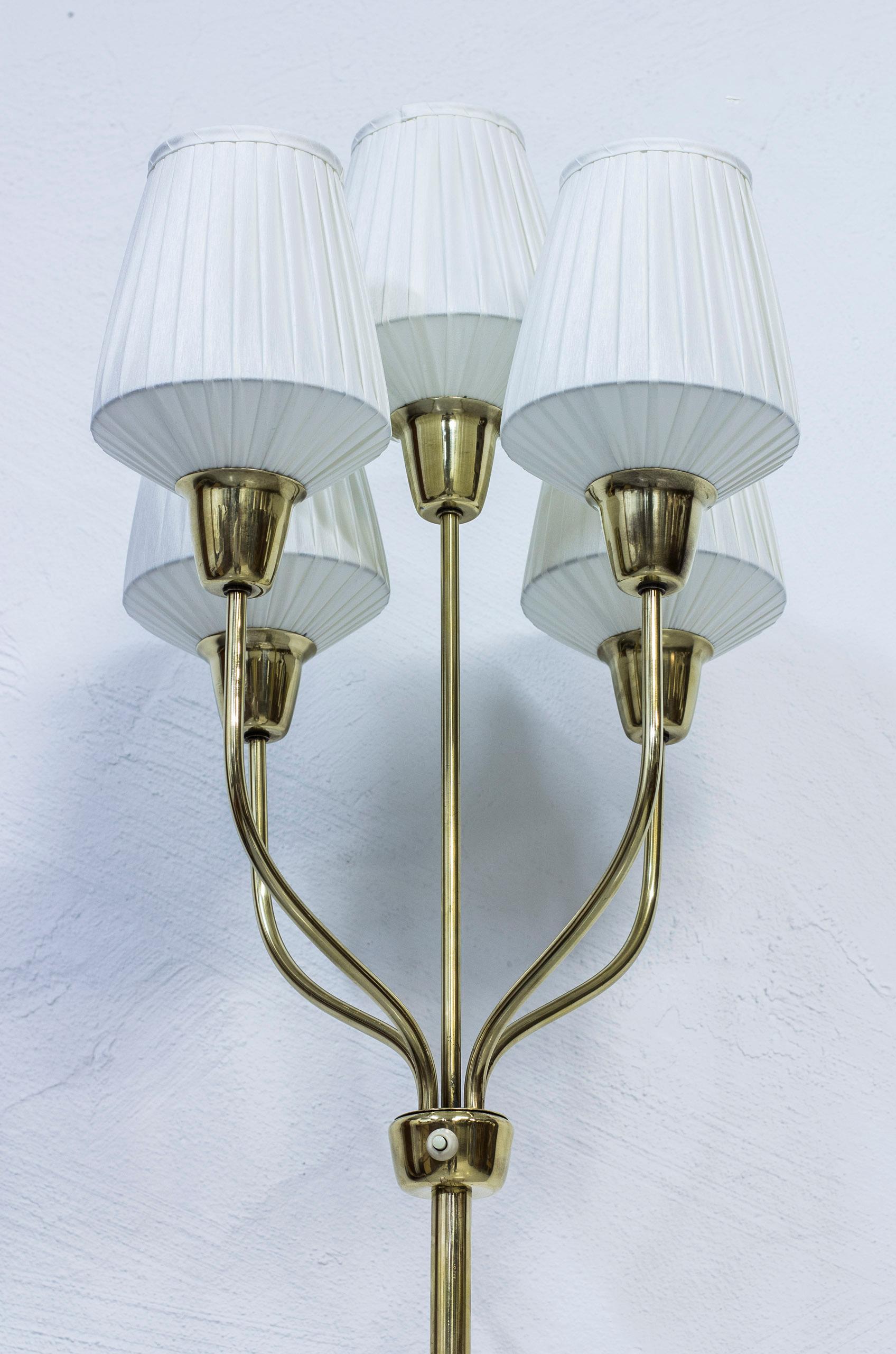 Rare floor lamp designed by Hans Bergström. Produced by his company Ateljé Lyktan in Åhus, Sweden, during the 1940s. Consisting of five organically shaped armes made from solid brass with original lamp shades that have been reupholstered with new