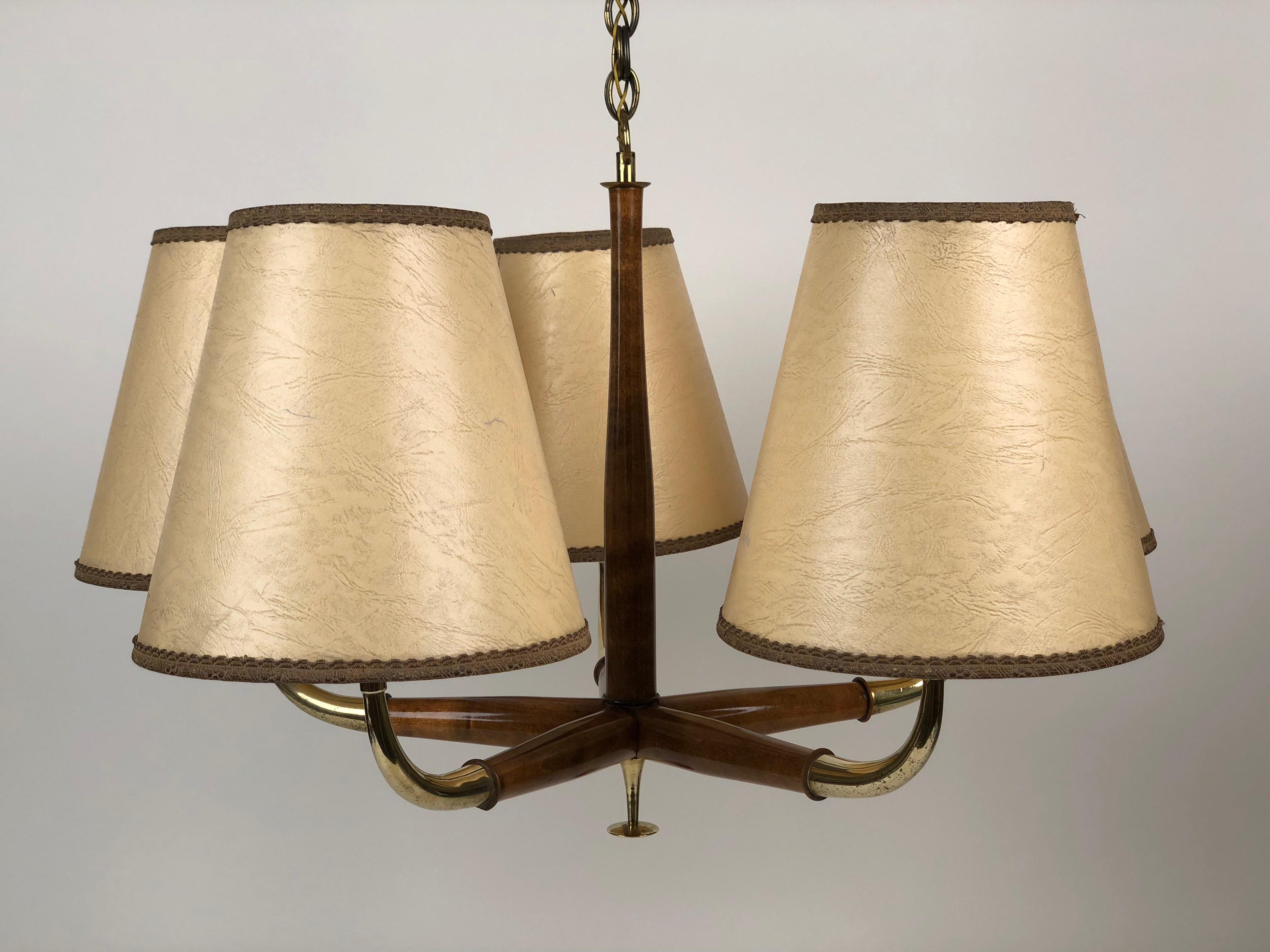 The chandelier has five arms, decorated with a button and an elegant double chain in brass.
The corpus is made from beech wood, stained in a walnut color. The shades are original.
One of the arms have a small chip in the wood. The chip is
