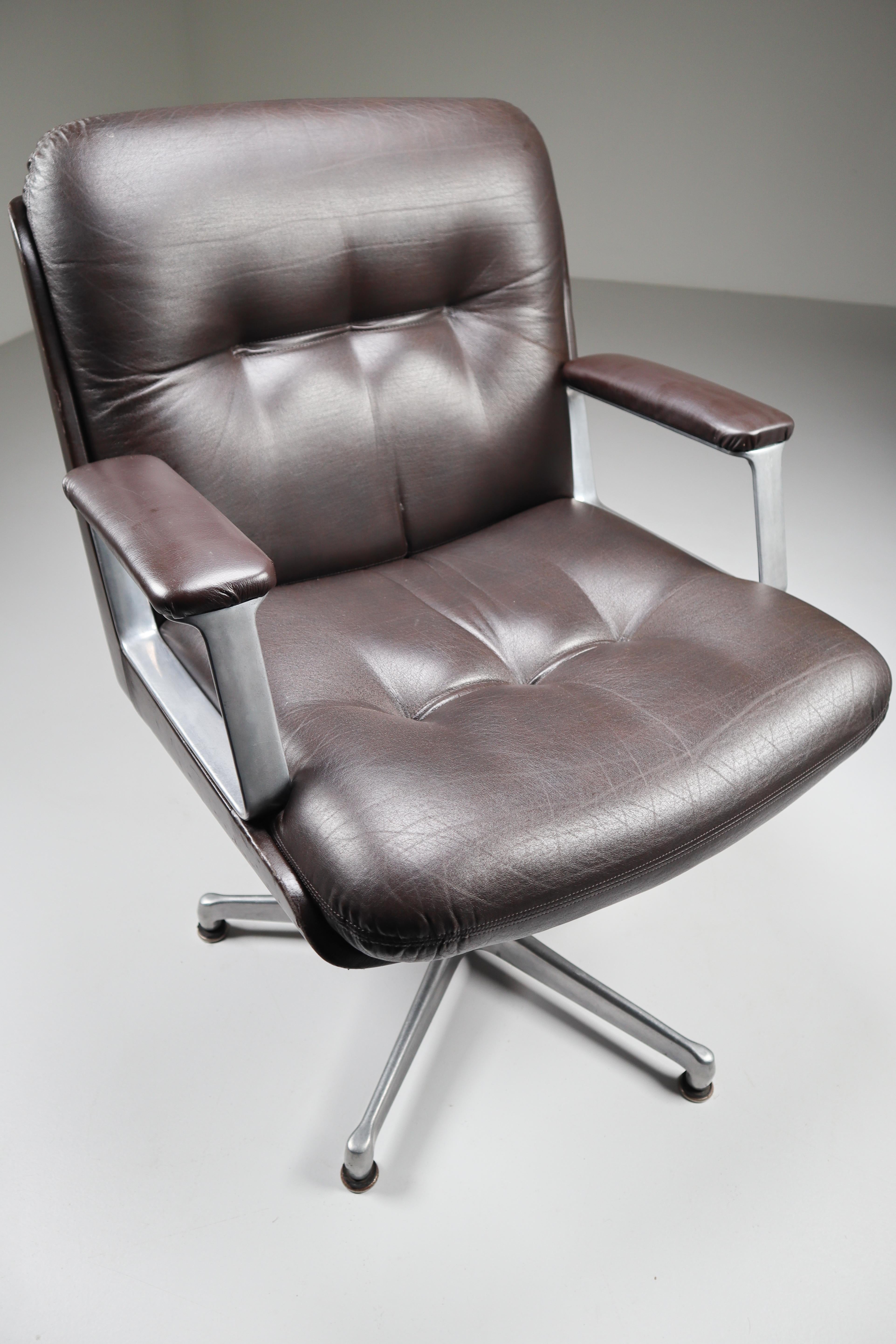 Executive office armchair by Osvaldo Borsani for the Italian manufacturer Tecno features an elegant brown leather body with a generously proportioned button-tufted leather seat and back and floating on a five-pronged cast aluminum base. Super