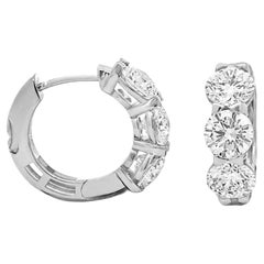 Orecchini a cerchio "huggie" con diamante da cinque carati creato in laboratorio e oro 14 carati