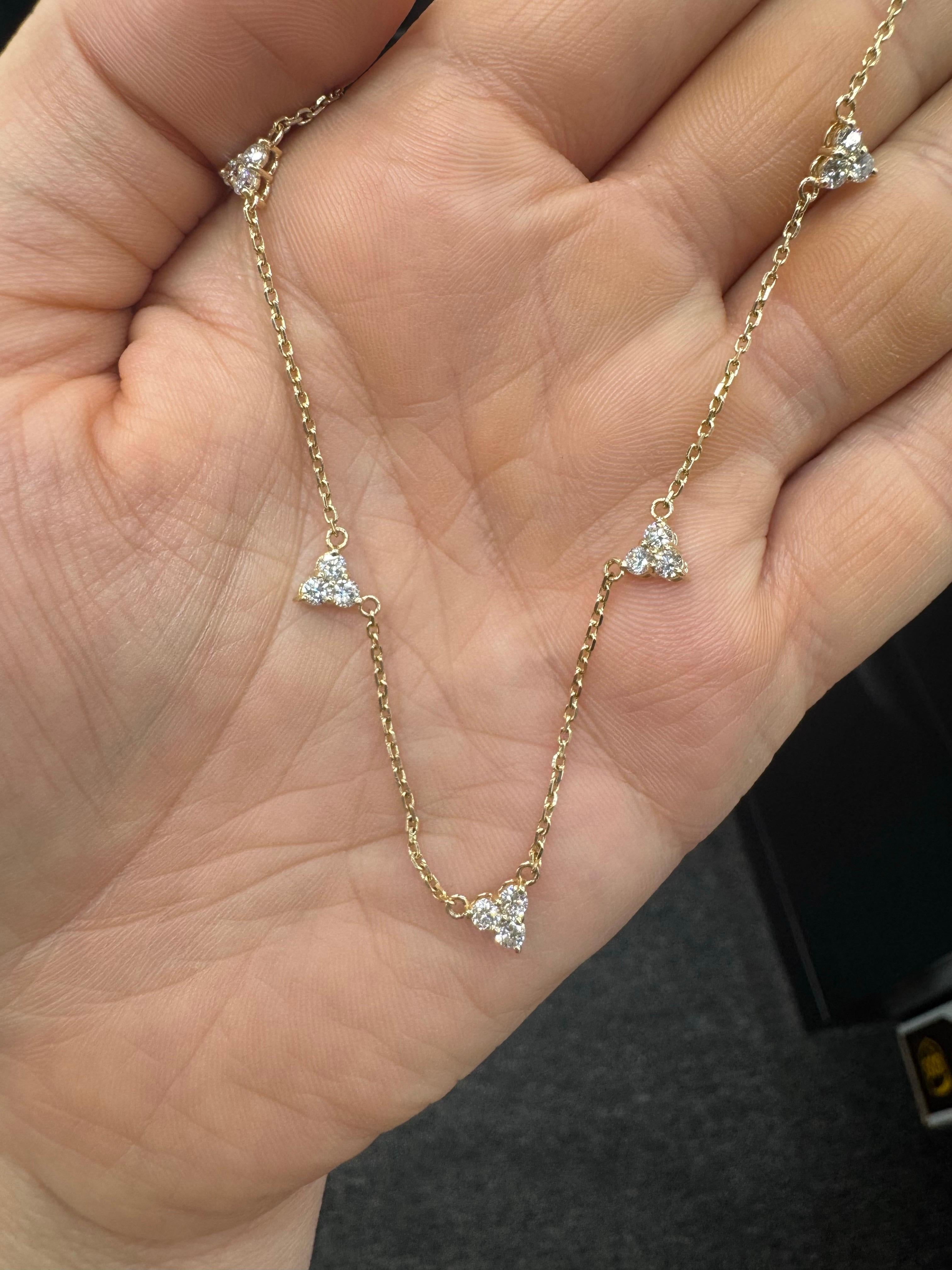 Crafted in 14 karat gold, this elegant necklace features five diamond clusters set along a fine chain. The 15 round brilliant diamonds total approximately 0.86 carats, graded F-G color and VS2-SI1 clarity, with each diamond averaging 0.06 carats.