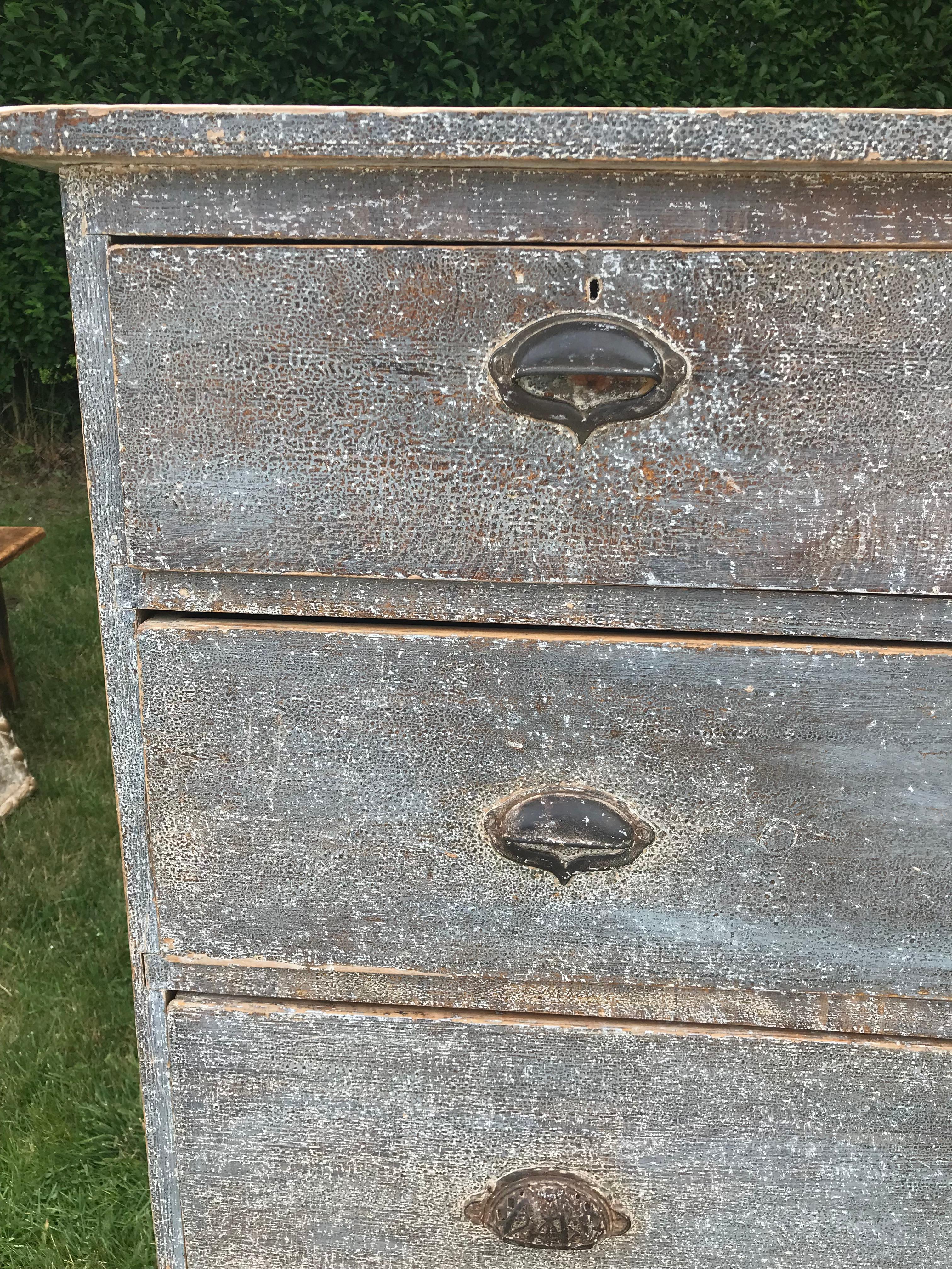 Five-drawer dresser with blue paint.
