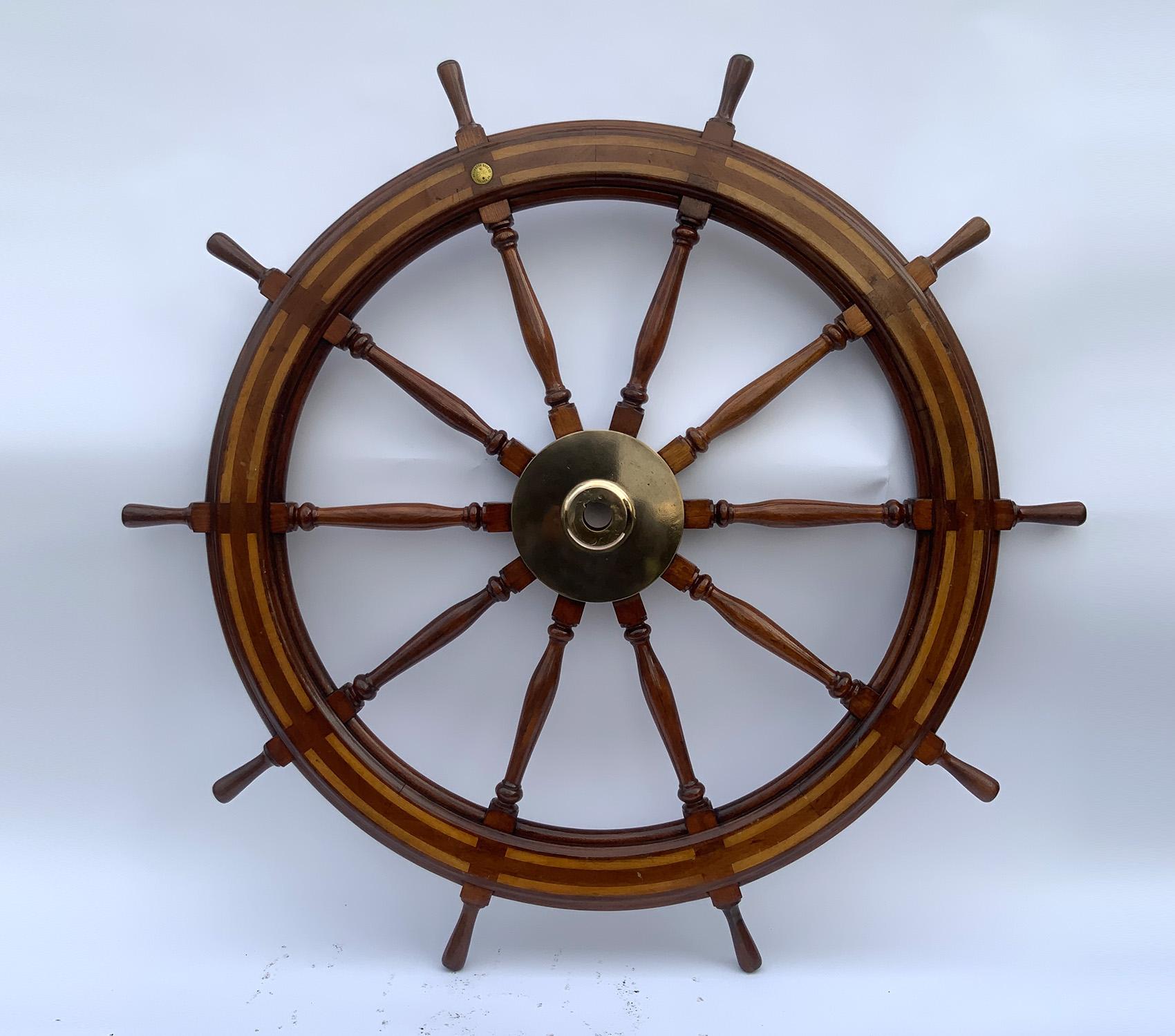 Exceptional sixty-four-inch mahogany ships wheel with maple inlay. Round brass medallion marked with makers name of Williamson Brothers of Philadelphia. Large solid brass hub. Note: There are some gouges on the hub on the rear side of the wheel,