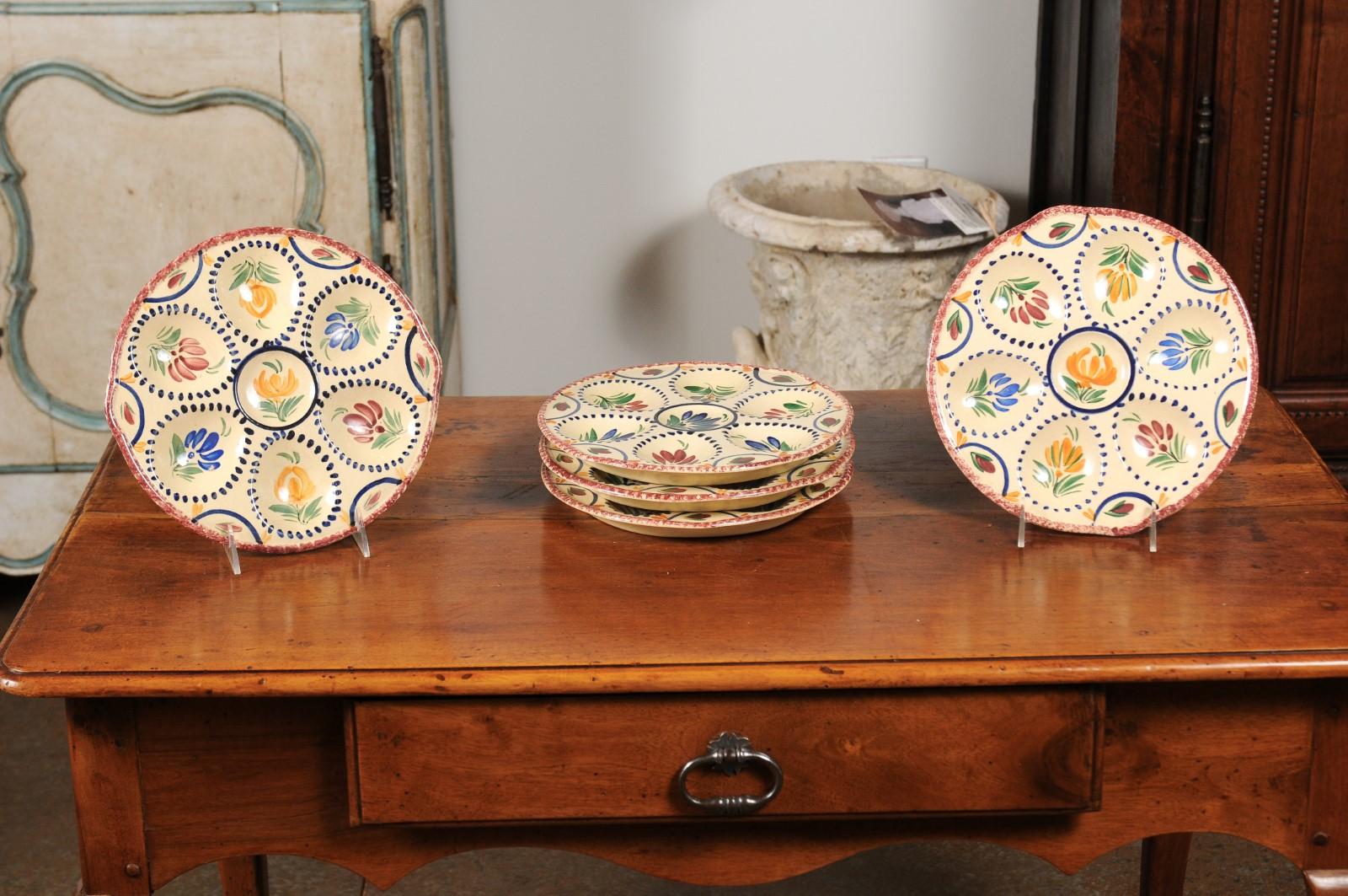 Eight French 19th century hand painted faïence oyster plates from Quimper from the HB manufacture presenting a floral décor, priced and sold individually. Born in the exquisite area of southern Brittany during the 19th century, this charming set of