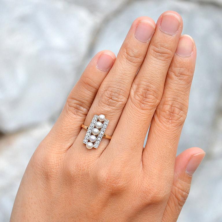 This ring sits fully with its five real and pure freshwater pearls elongating your pretty fingers and shimmering tiny diamonds on both sides. 

Ring Information
Style: Vintage
Metal: 9K Yellow Gold
Total weight: 3.63 g. (approx. total
