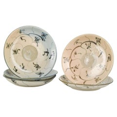 Cinque ciotole coreane in gres prodotte a mano con motivi floreali e di vite.