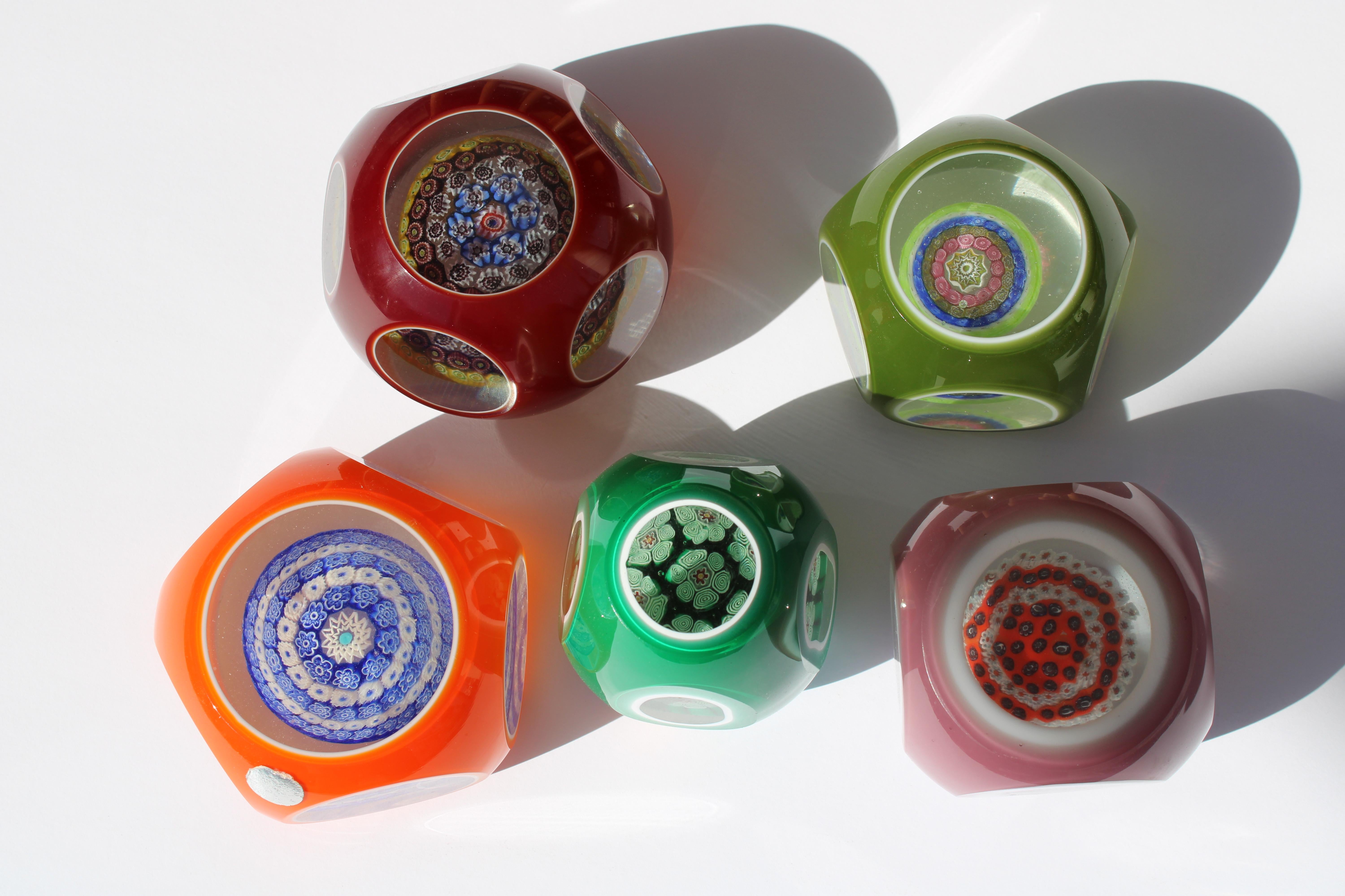 Five Italian Murano millefiori cased glass paperweights.  They range from 2.25
