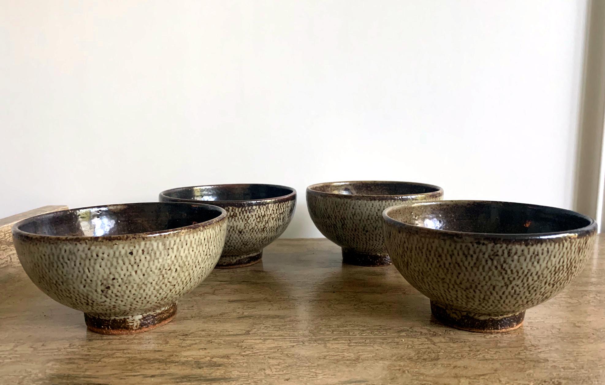 A set of five Japanese ceramic bowls by Tatsuzo Shimaoka (?? ??; 1919-2007), an important member in Japanese Mingei Folk Art movement. The collection consists of a matching set of four tea bowls and an additional one of a different shape but same