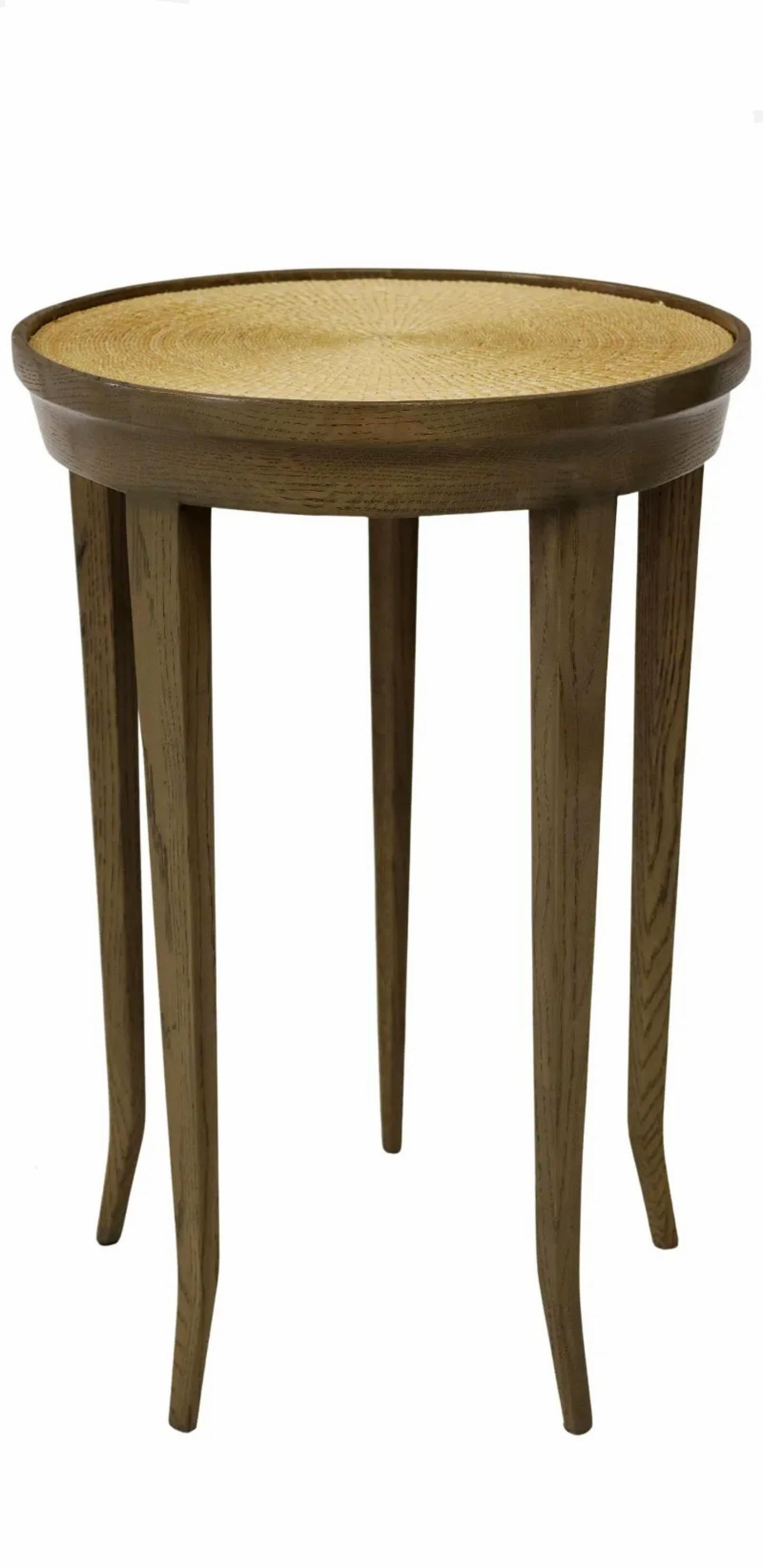 A high-quality designer five legged painted wood and wicker occasional table, 20th century, simple yet distinctive sculptural silhouette, having a circular top with inset wicker design, rising on five tapered square legs.

Provenance /