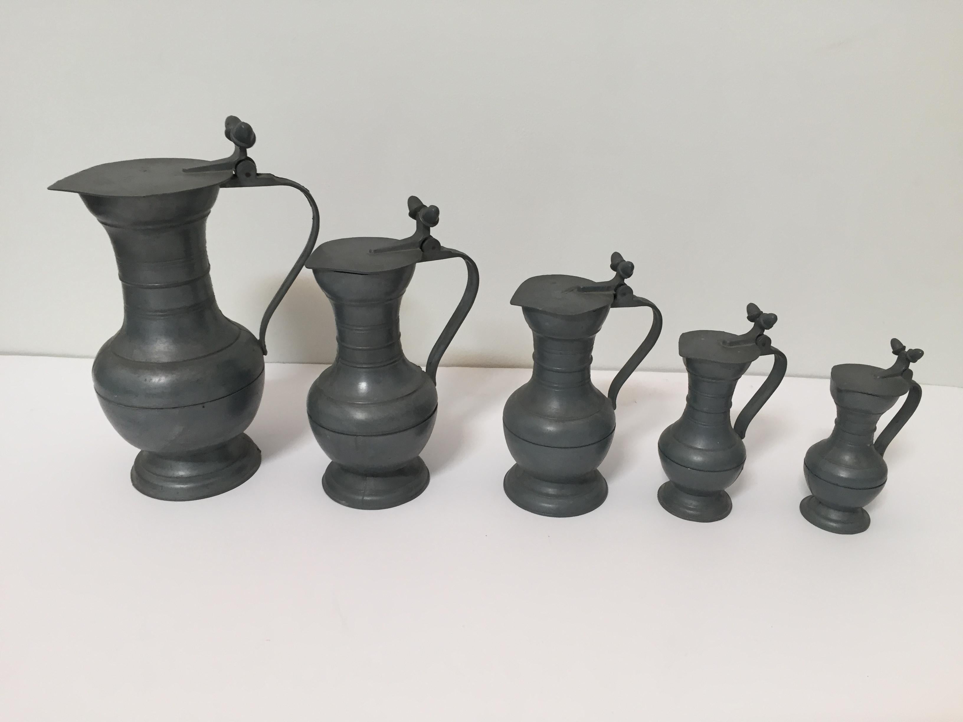 Antique Dutch Holland pewter angel marked tin set of five lidded mugs pitcher
Decorative lidded pewter jugs, Netherlands.
Five pewter lidded pitchers with acorn finials.
Pewter drinking vessel orpitcher with acorn thumb rest, it has a lipped lid and