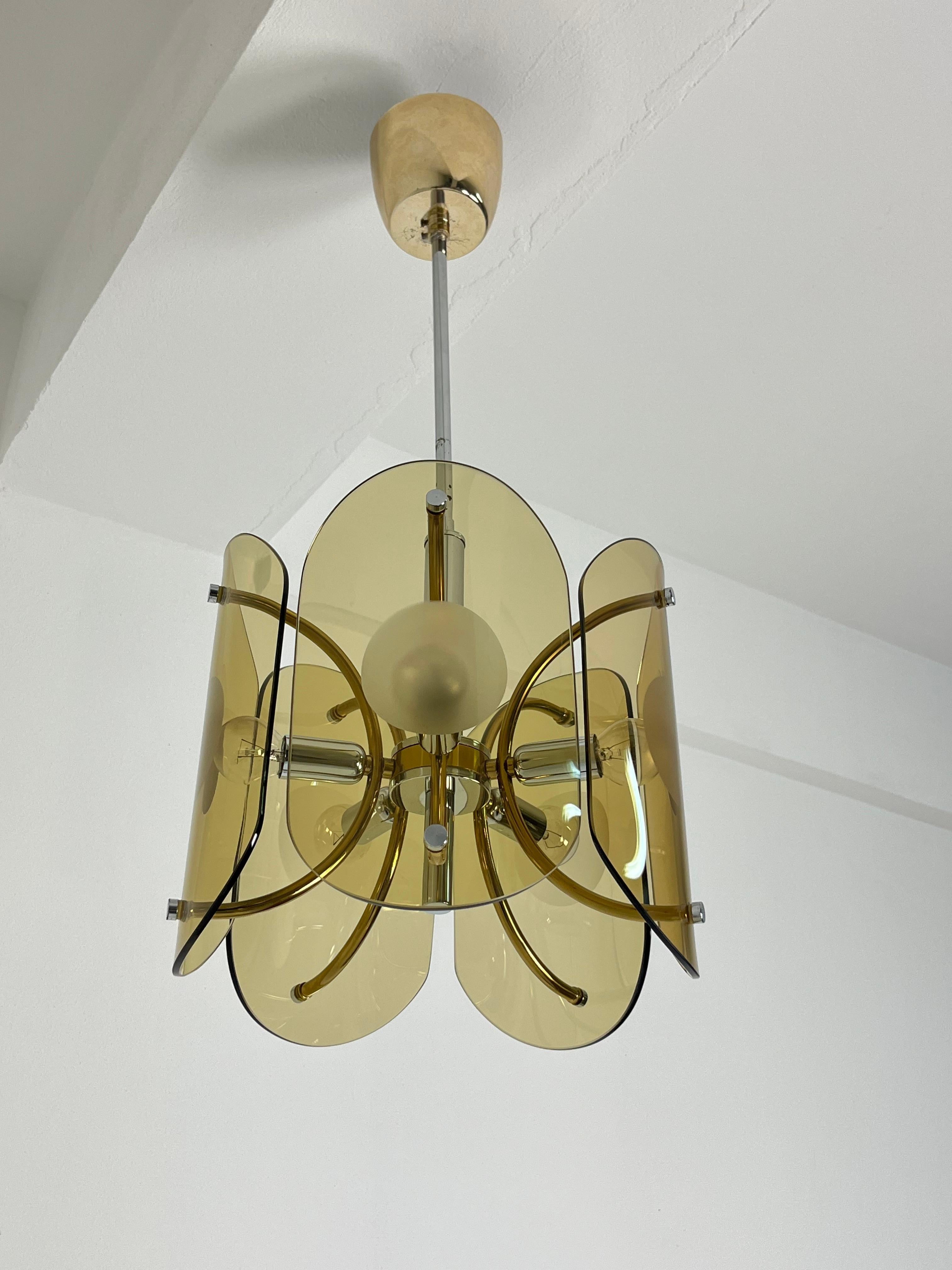 Lampadario a cinque luci in vetro di Murano color ambra, anni '70
Struttura in metallo cromato, lampadine E14.
Vetro intatto, buone condizioni.