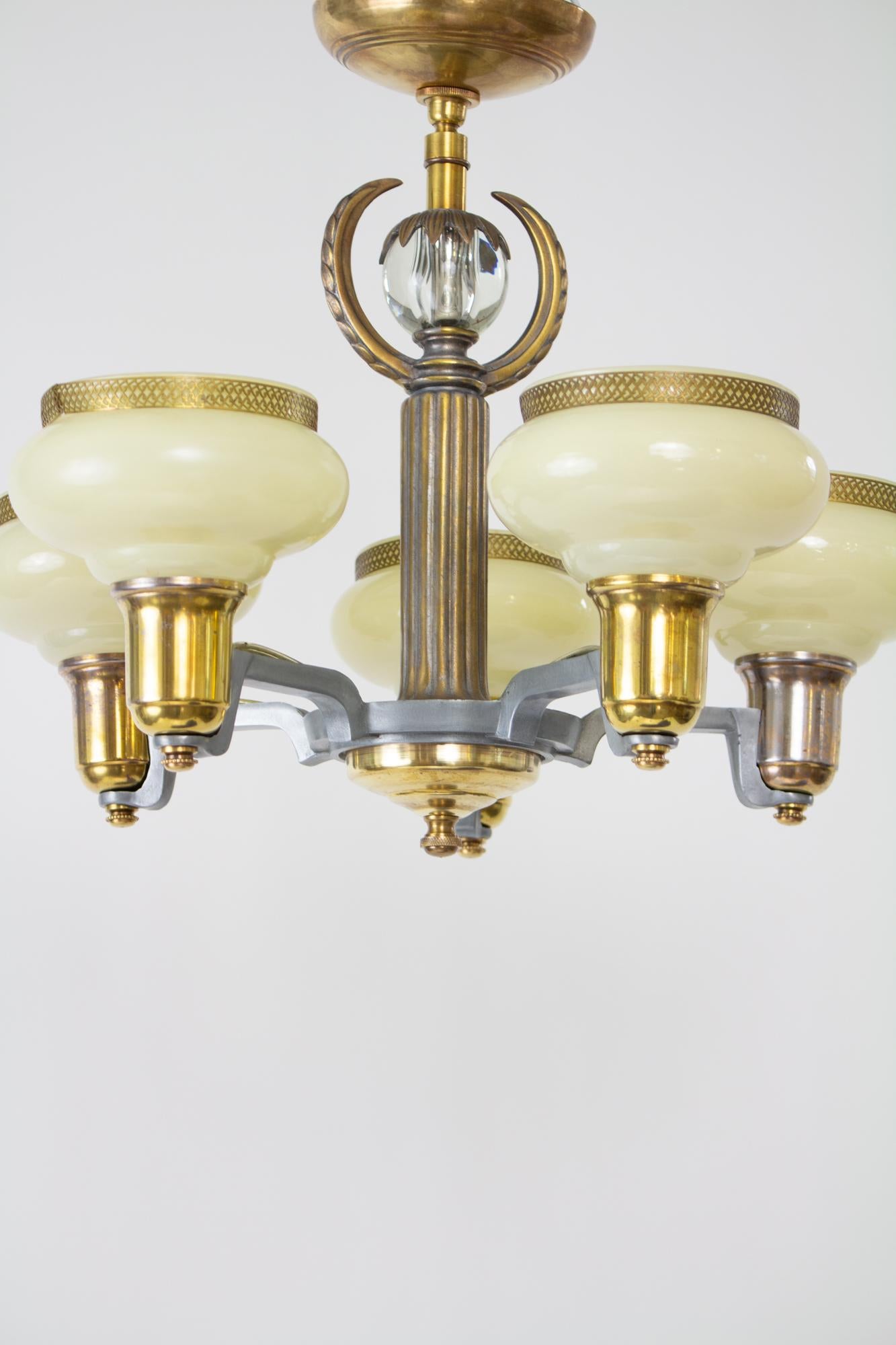 Five light art deco custard glass chandelier. Combination cast metal and brass. Center stem has a glass ball with a wreath. Direct mounts to ceiling box with a swivel, so it is an excellent choice for low ceilings