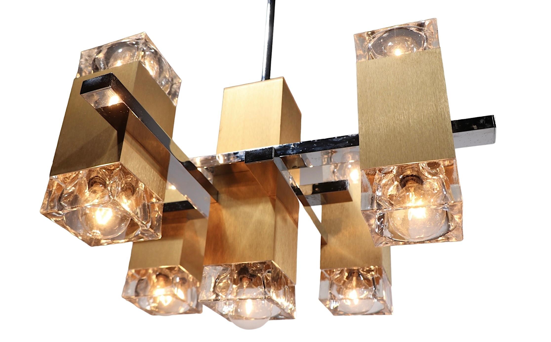Lámpara de araña de estilo Hollywood Regency, Postmoderno y Art Decó Revival, fabricada por Sciolari, hacia la década de 1970. 
 La araña presenta nueve bombillas, cada una rodeada por una pantalla de cristal fundido similar a un cubito de hielo,