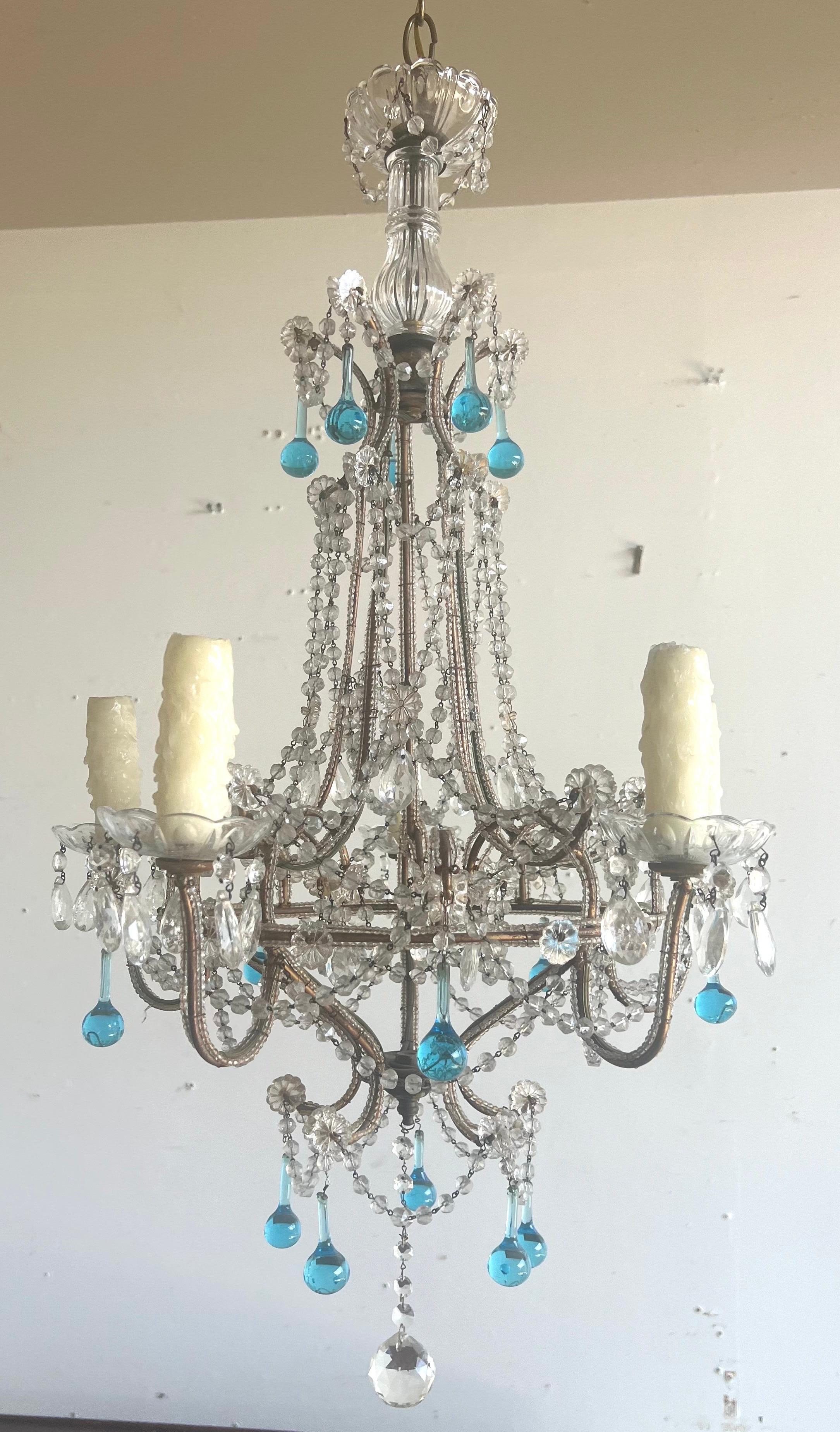 Lustre à cinq branches en cristal perlé avec des gouttes turquoise et transparentes.  Il comporte une colonne centrale ornée de guirlandes de perles anglaises taillées et de pièces métalliques. Le lustre est composé de cinq bras, chacun supportant