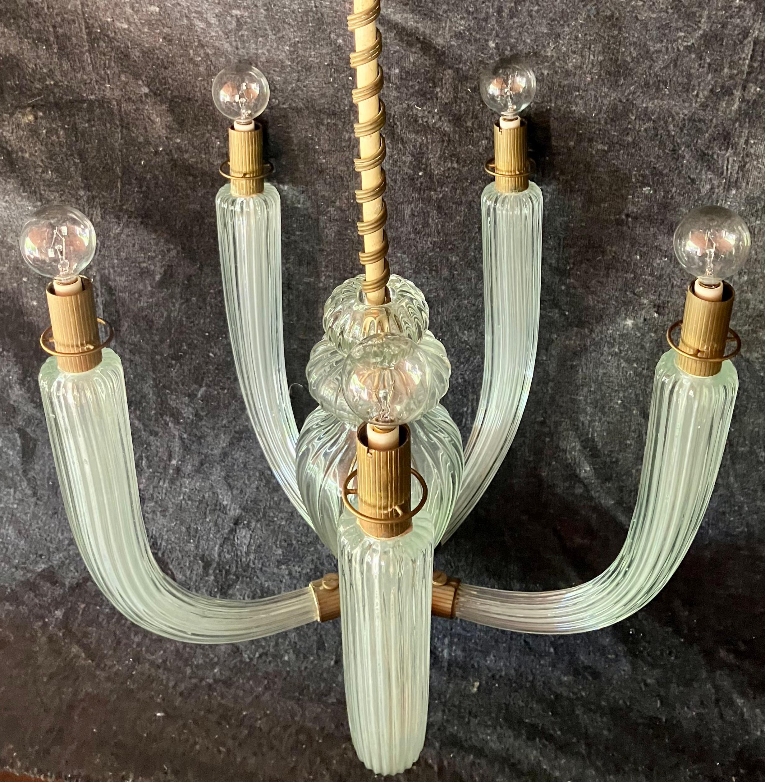Five light Murano Chandelier. Five arm moderne pendant in palest green reeded glass with central baluster issuing coiled brass on white painted metal stem spiraling up to gold painted and reeded metal  canopy. Lacking original glass globes. Carlo