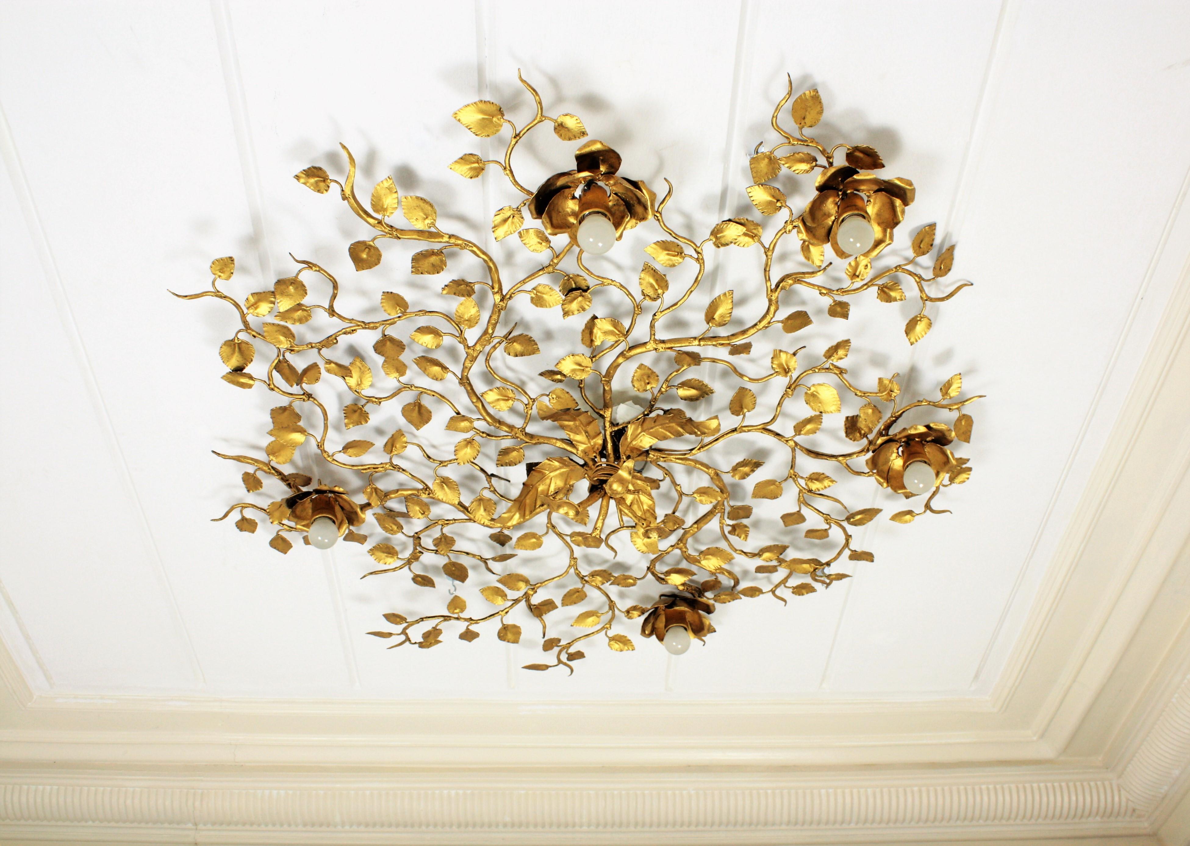 Outstanding large size hand-hammered gilt iron ornate flower bush ceiling light fixture with five flower lights. An spectacular Hollywood Regency style piece to preside a main room or a living room. This light fixture could also work as a big wall