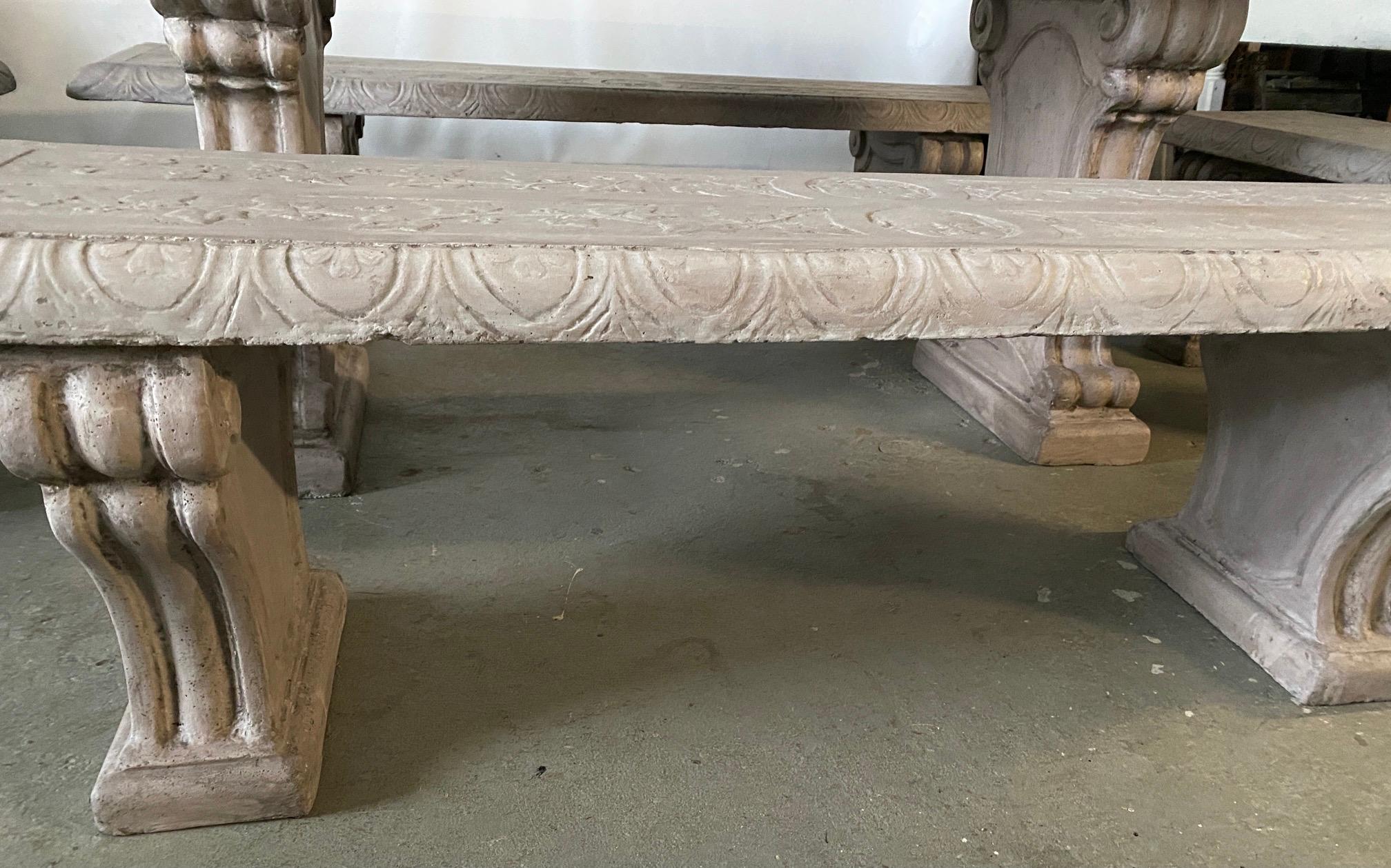 The five pieces include a dining table (two pedestal bases and top), two long benches (two pedestal bases and seat each) and two short benches (two pedestal bases and seat each). The surfaces of the top and seats have etched designs including faces,