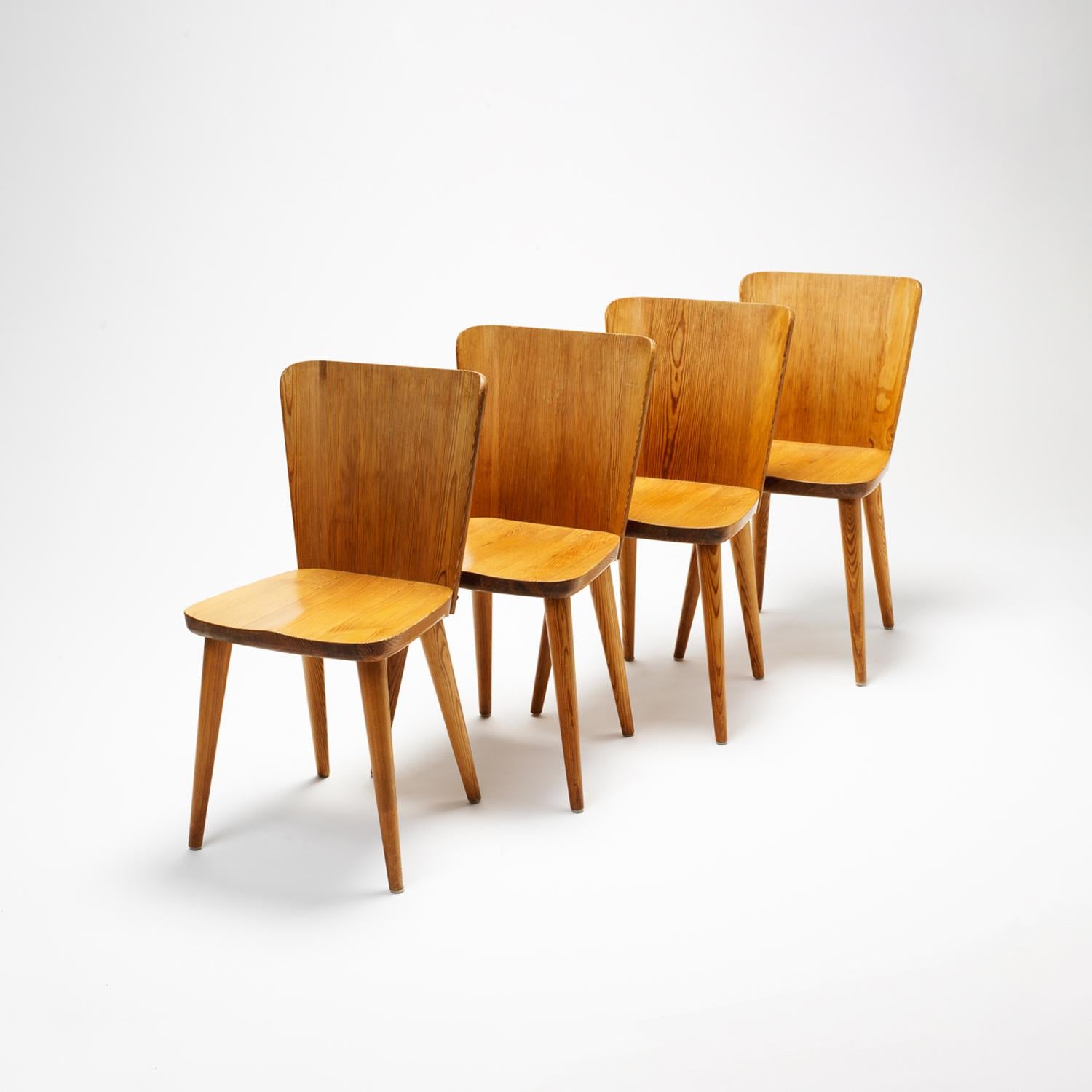 A set of four Model 510 Svensk Fur dining chairs and dining table in solid Swedish pitch pine. The chairs display Malmvall’s classic thermo-formed curved backs and conical tilted legs. In excellent vintage condition. In the style of Axel Einar