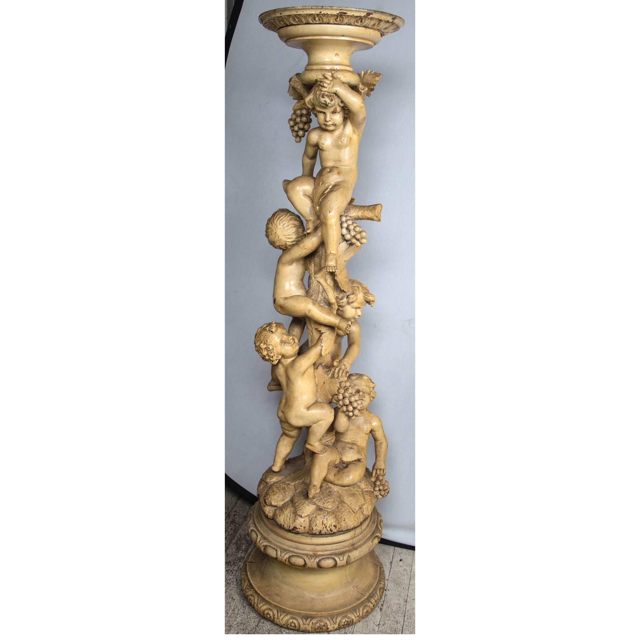 Hand-carved of a hard wood and painted in deep cream color. Five putti amid grape leaves and bunches of grapes on a realistic column of vine.