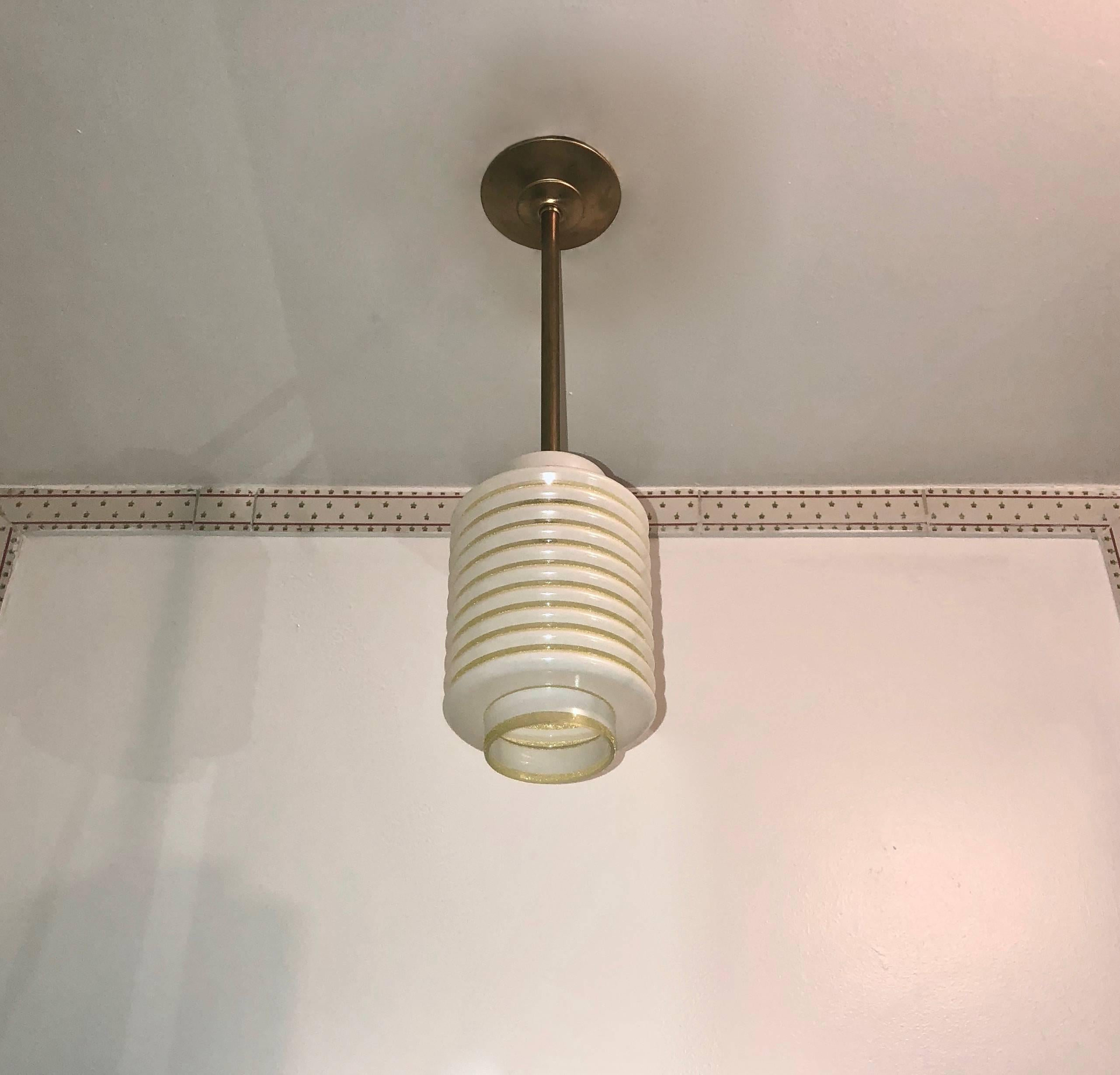 Five French ceiling lights in large-ribbed glass with decorative yellow bands . Each light hangs from a brass stem and canopy. Each fixture has been rewired to a single American candelabra socket.
Original label 