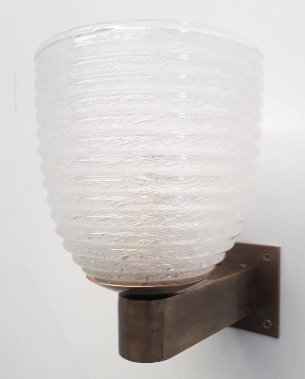 Original vintage Italian wall light with clear Murano glass hand blown in ribbed patterns and bubbles within the glass in Pulegoso technique, mounted on brass bracket with great vintage patina / Designed by Barovier e Toso, circa 1960s. Original