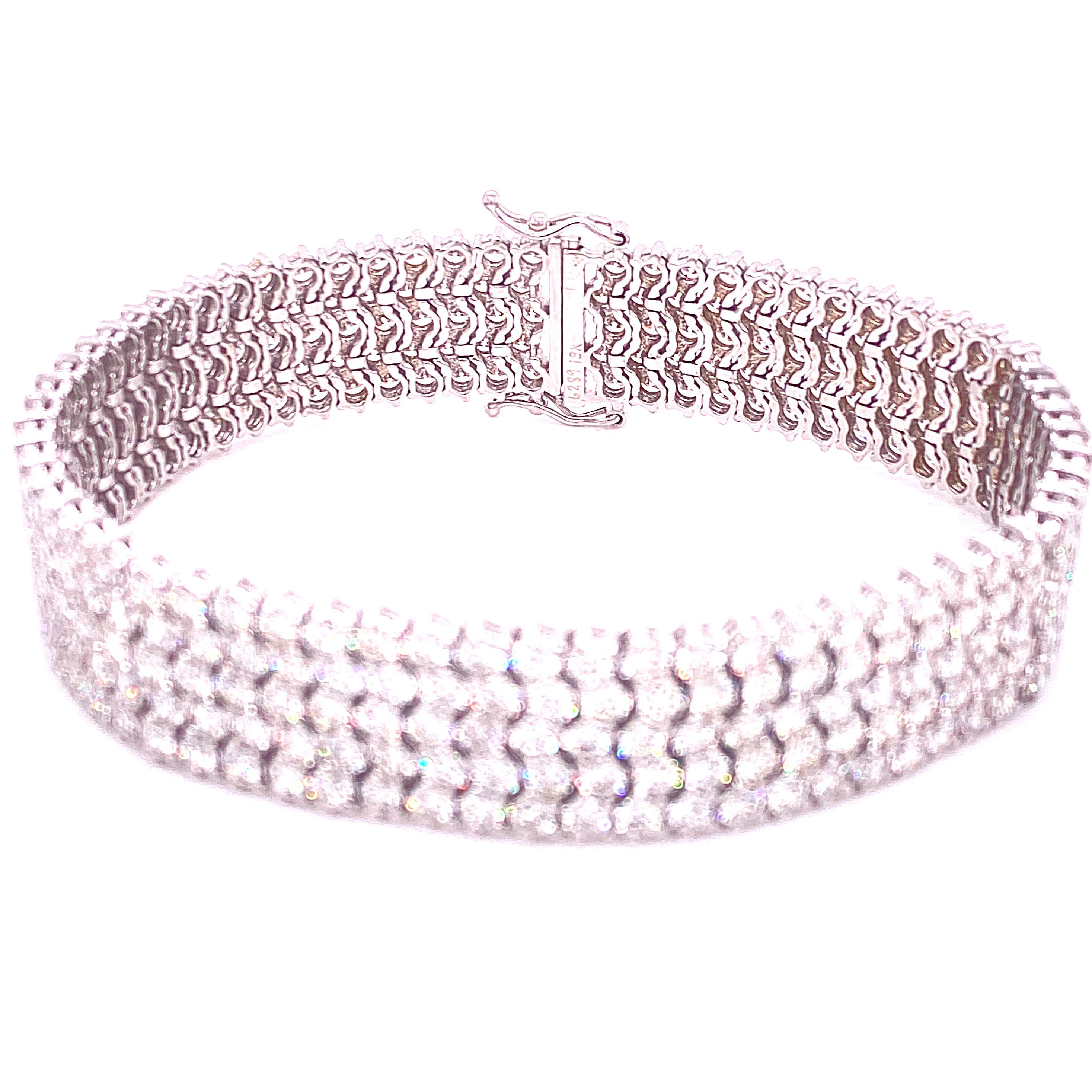 Glamorous five row diamond bracelet fashioned in 18 karat white gold. The shimmering round brilliant cut diamonds weigh 19.09 carats and are graded G-H color and VS-SI1 clarity. The bracelet is beautifully crafted with flexible links that lay