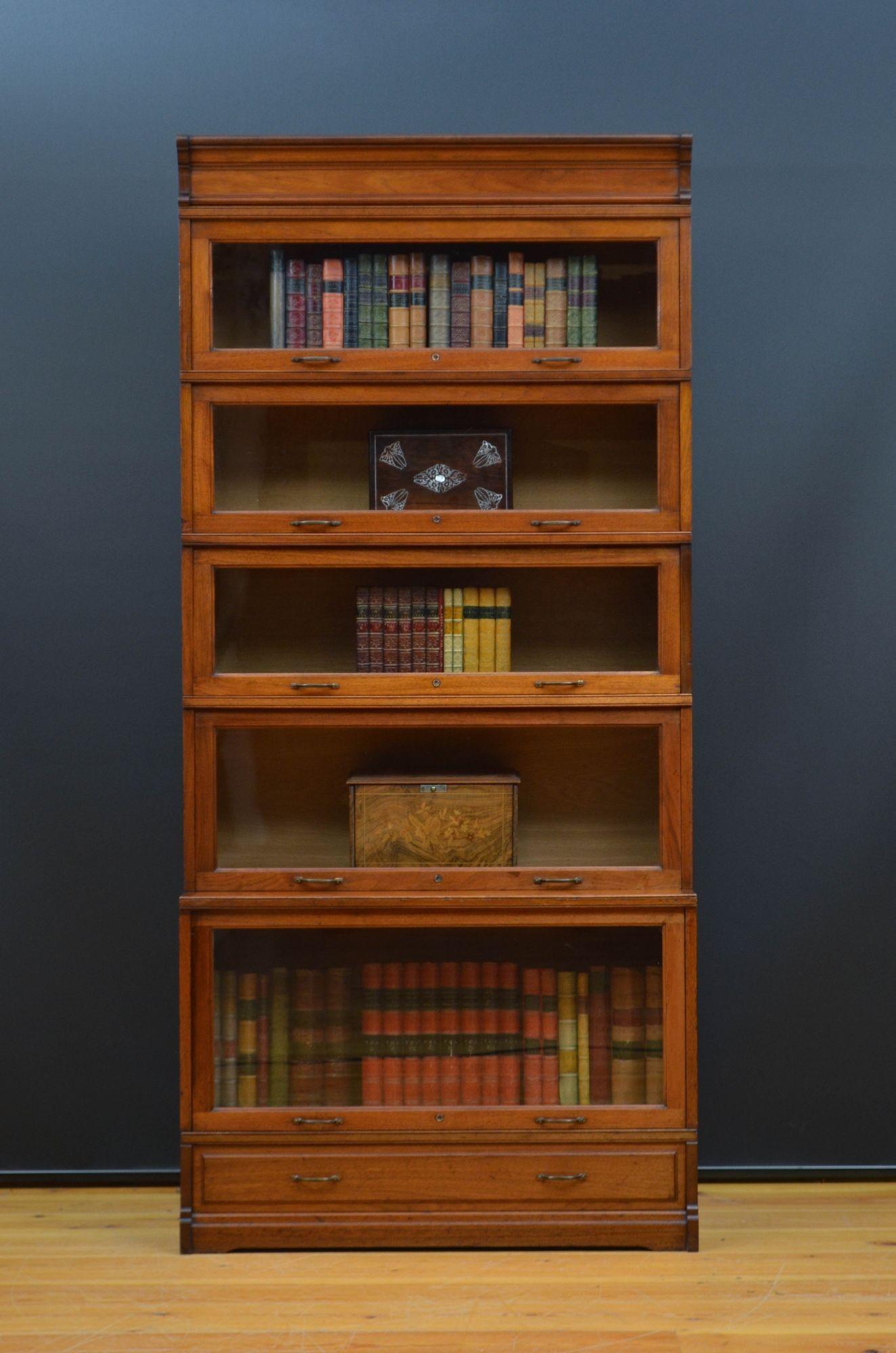 Sn5548 Fine quality solid walnut and solid oak five section stacking bookcase, having five graduated sections fitted with locking mechanism, original brass handles and original glass above an oak line fielded base drawer. This antique bookcase