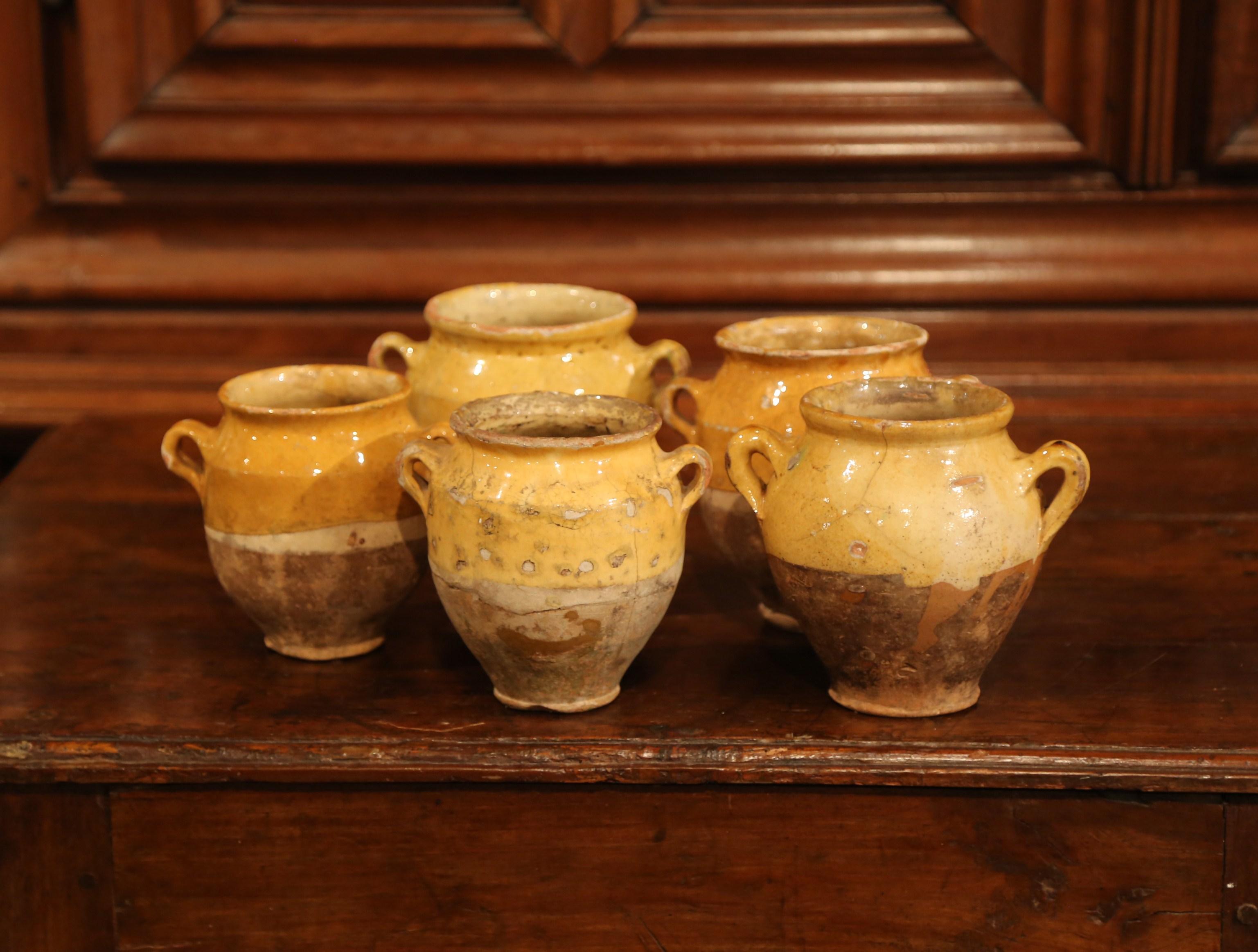 Very difficult to find in a small-scale, each of these antique confit pots were found and crafted in the southwest region of France, circa 1880. Made of earthenware, these traditional vessels were once used daily in the French country home for