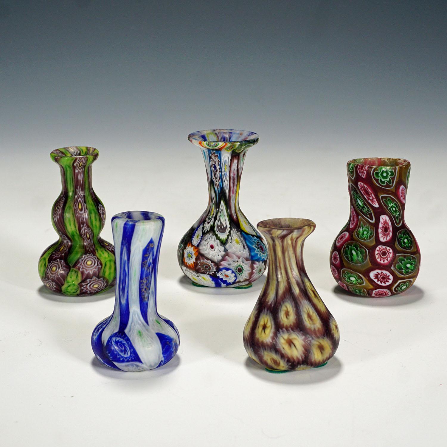 A set of five small murrine glass vases, manufactured by Vetreria Fratelli Toso around 1910. The vases are executed with polychrome multicoloured millefiori murrines and have an acid etched matte finish. The vases are authentic examples of early