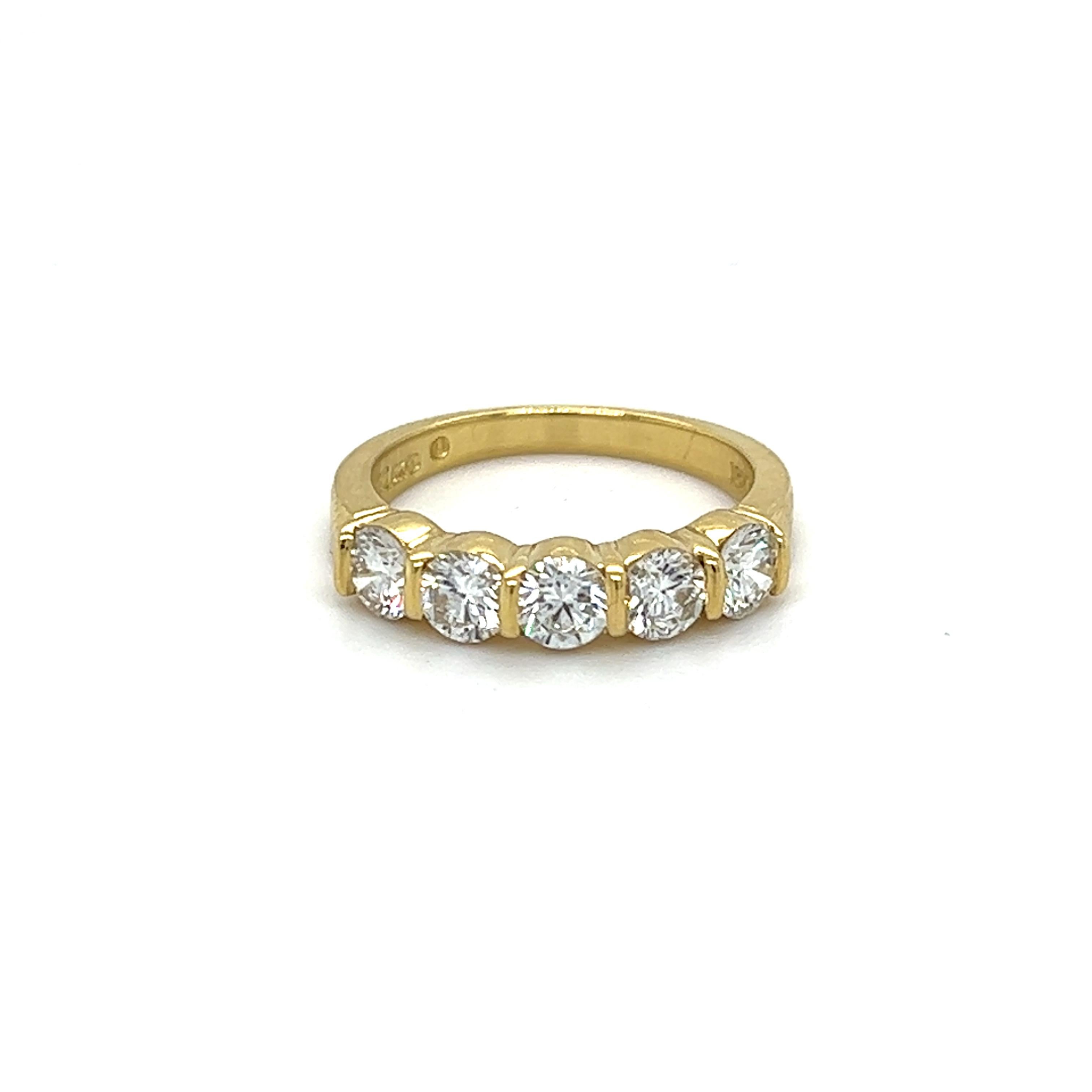 One 18 karat yellow gold band ring, bar set with five (5) round brilliant cut diamonds, approximately 1.00 carat total weight with matching I/J color and VS clarity. The ring is stamped 18K GEMLOK and weighs 3.8 grams total weight.  The ring is a