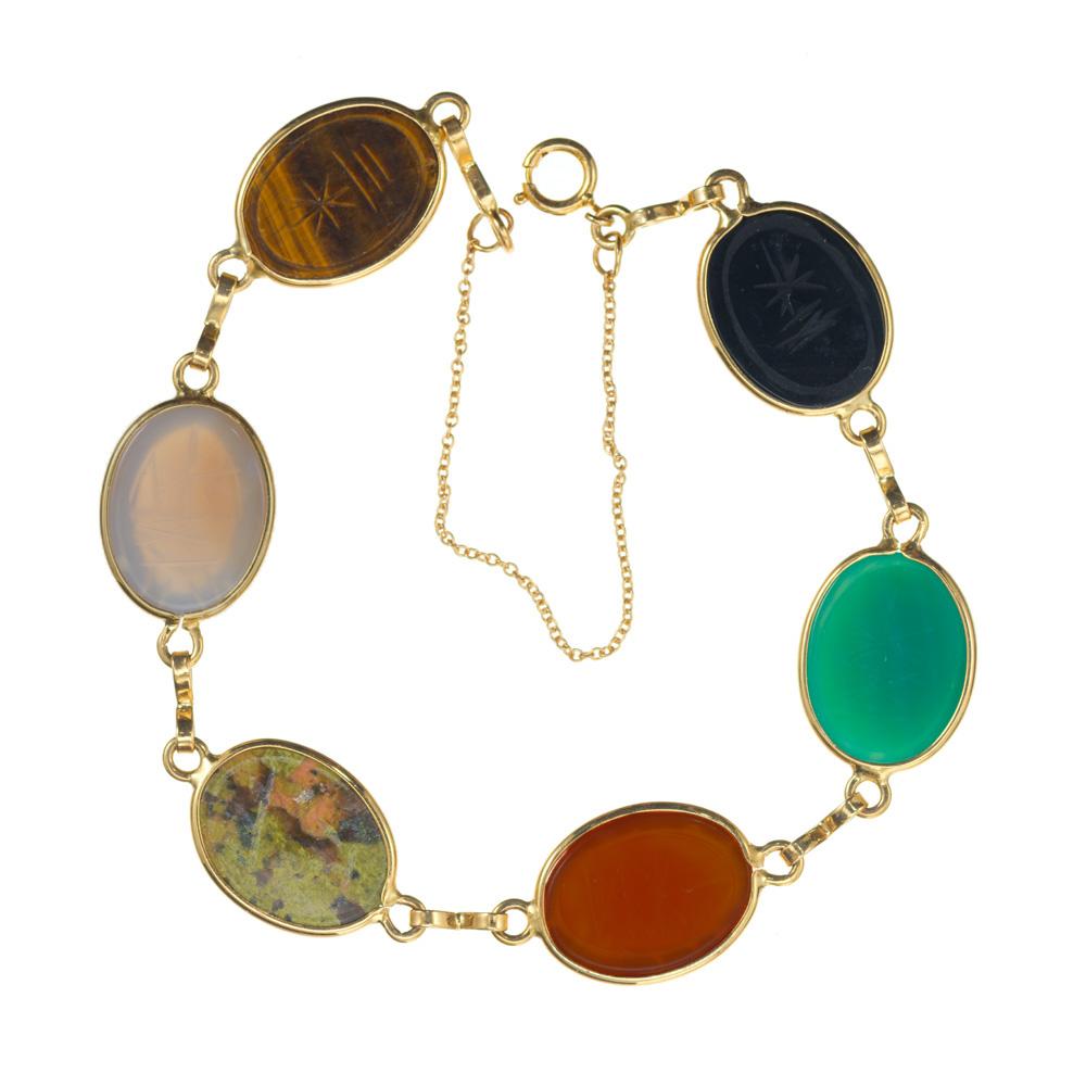 Five stone carved scarab bracelet in solid 14k yellow gold. Oval cabochon bezel set scarabs, connected together by oval yellow gold links. 7.5 inches in length.

5 oval cabochon  gemstones; tigers eye, bloodstone, carnelian, green agate, onyx,