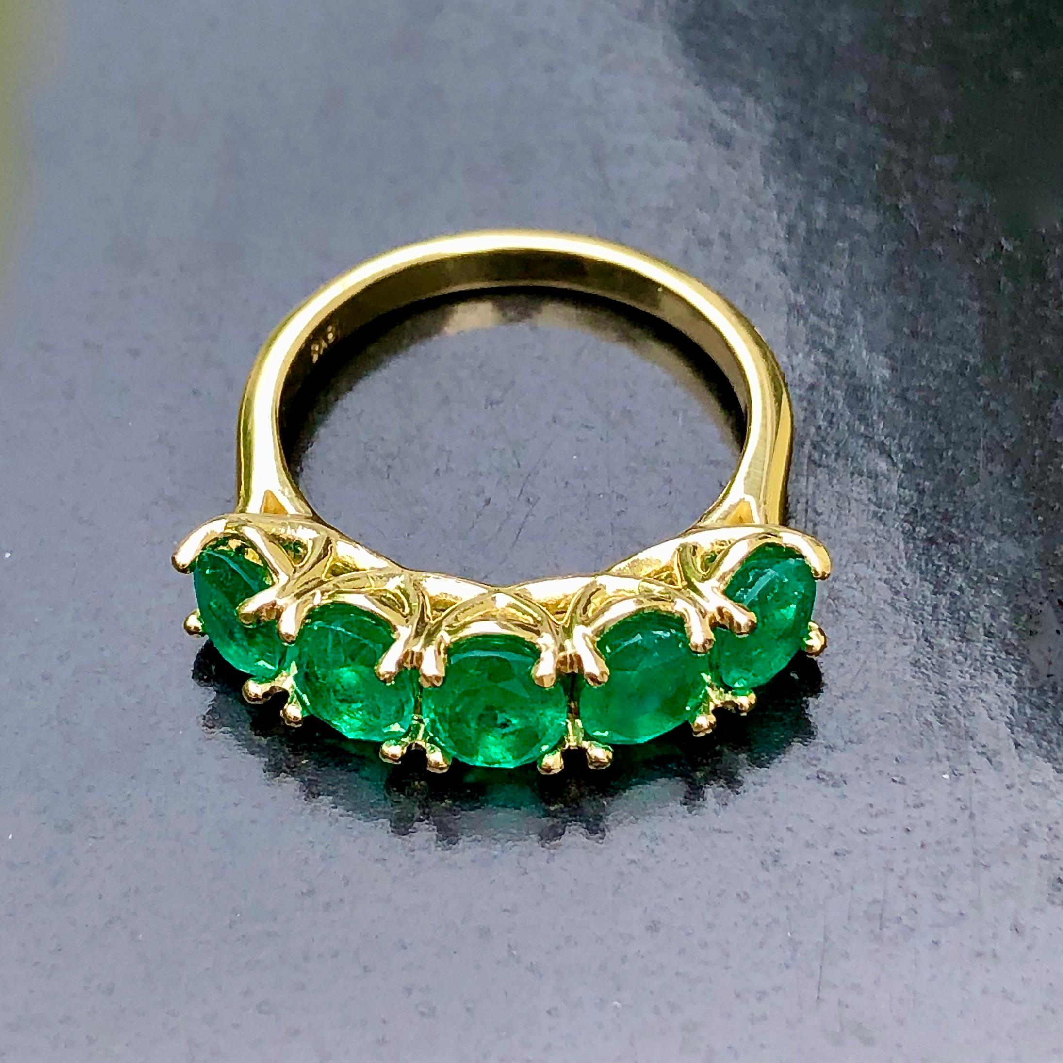 A classic emerald five stone ring. The graduated half-hoop of oval-cut Colombian natural emeralds, excellent color and clarity, highlighted with a scrolling gallery, mounted in 18K yellow gold. Victorian style, five stone rings were popular in the