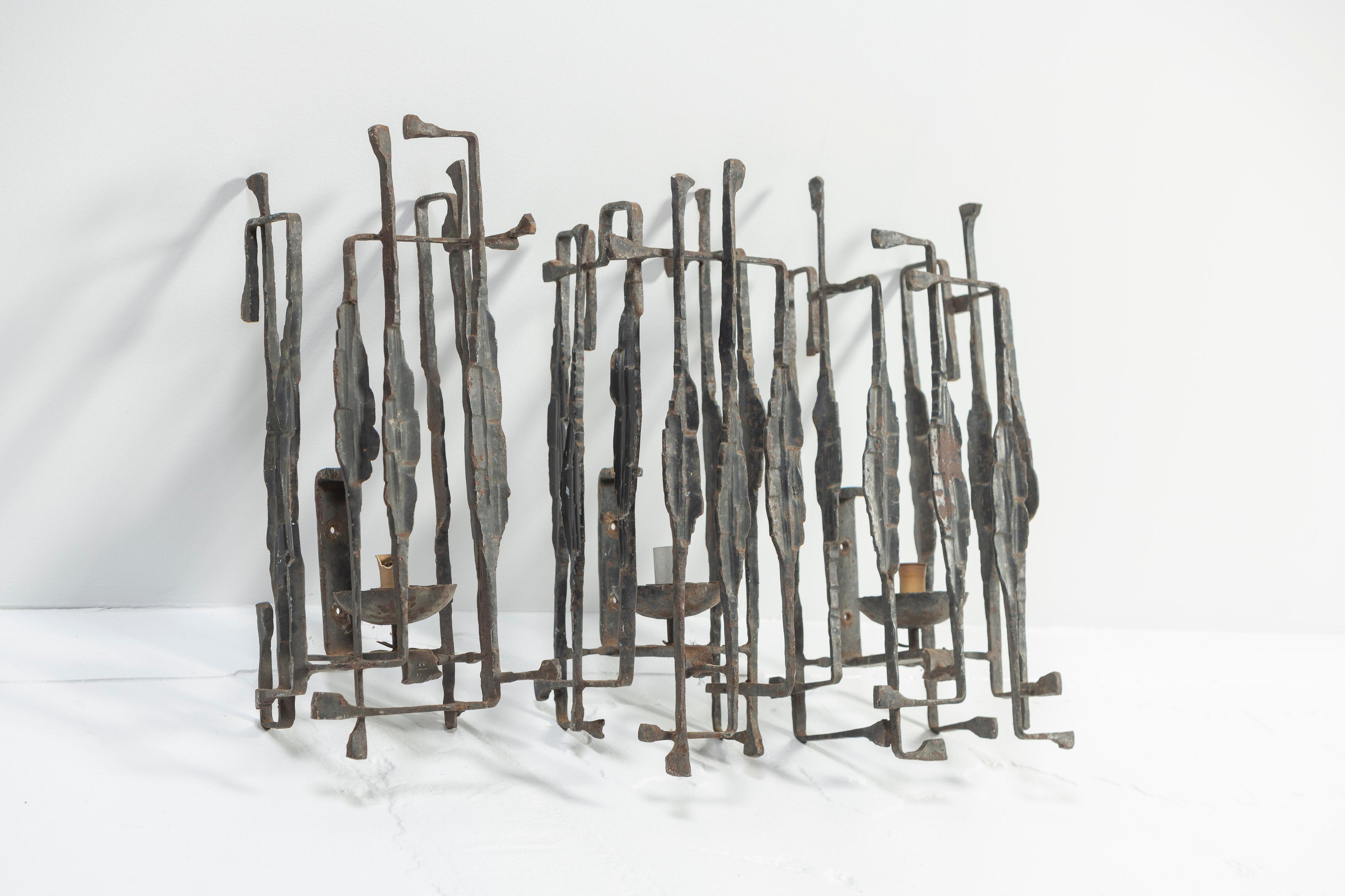 Five vintage wrought iron candle sconces in the Brutalist style will certainly light up a room and create interesting shadows. Sculptured and patinated, each iron piece holds a single taper candle, and each piece is unique. The set is modern and