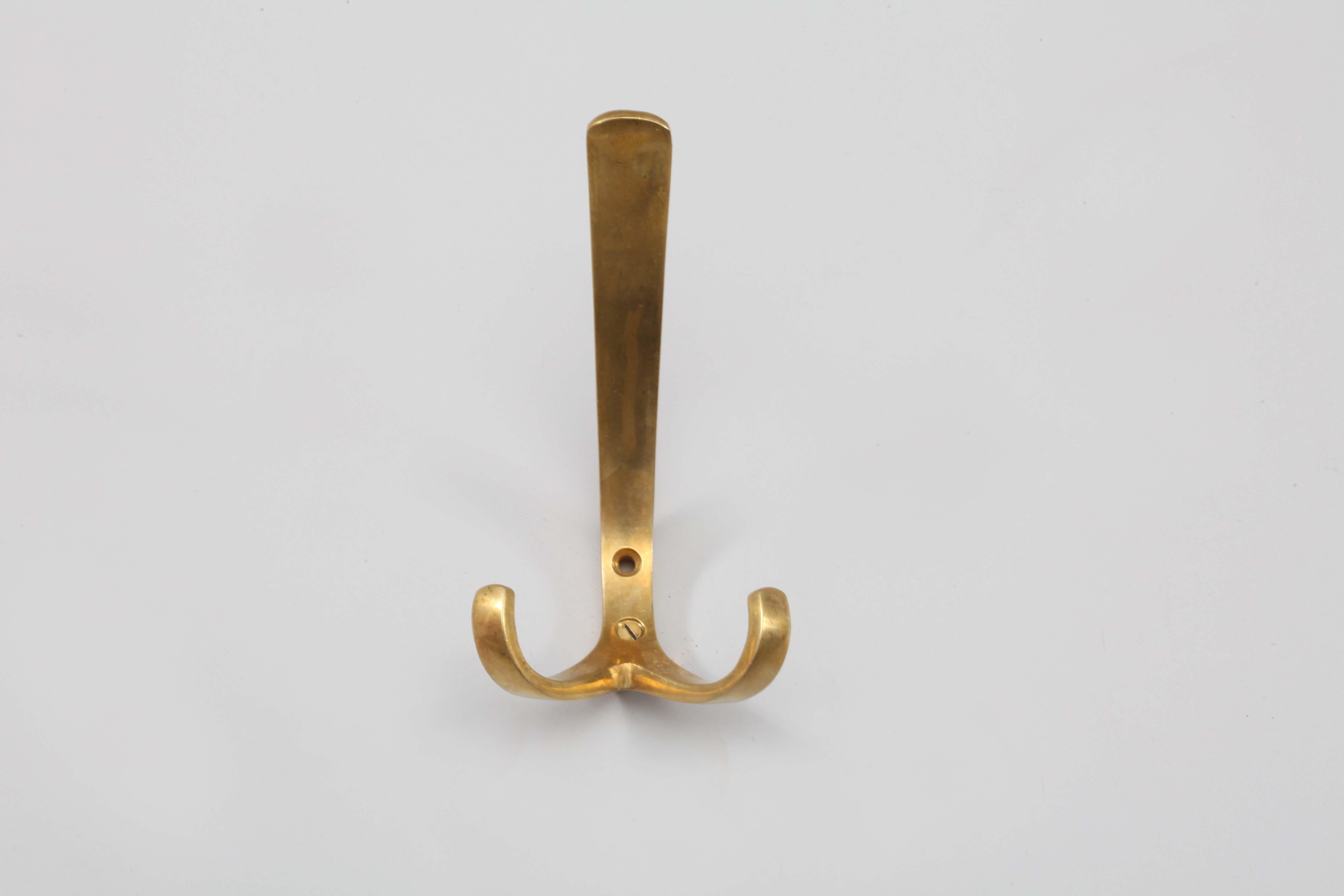 Five wall-mounted brass hooks, with a contrasting faux patina. 
Designed by Herha Baller,
Vienna, 1950.
Measures: height 6 inch (16cm), width 3 inch (7cm), depth 4 inch (11cm).