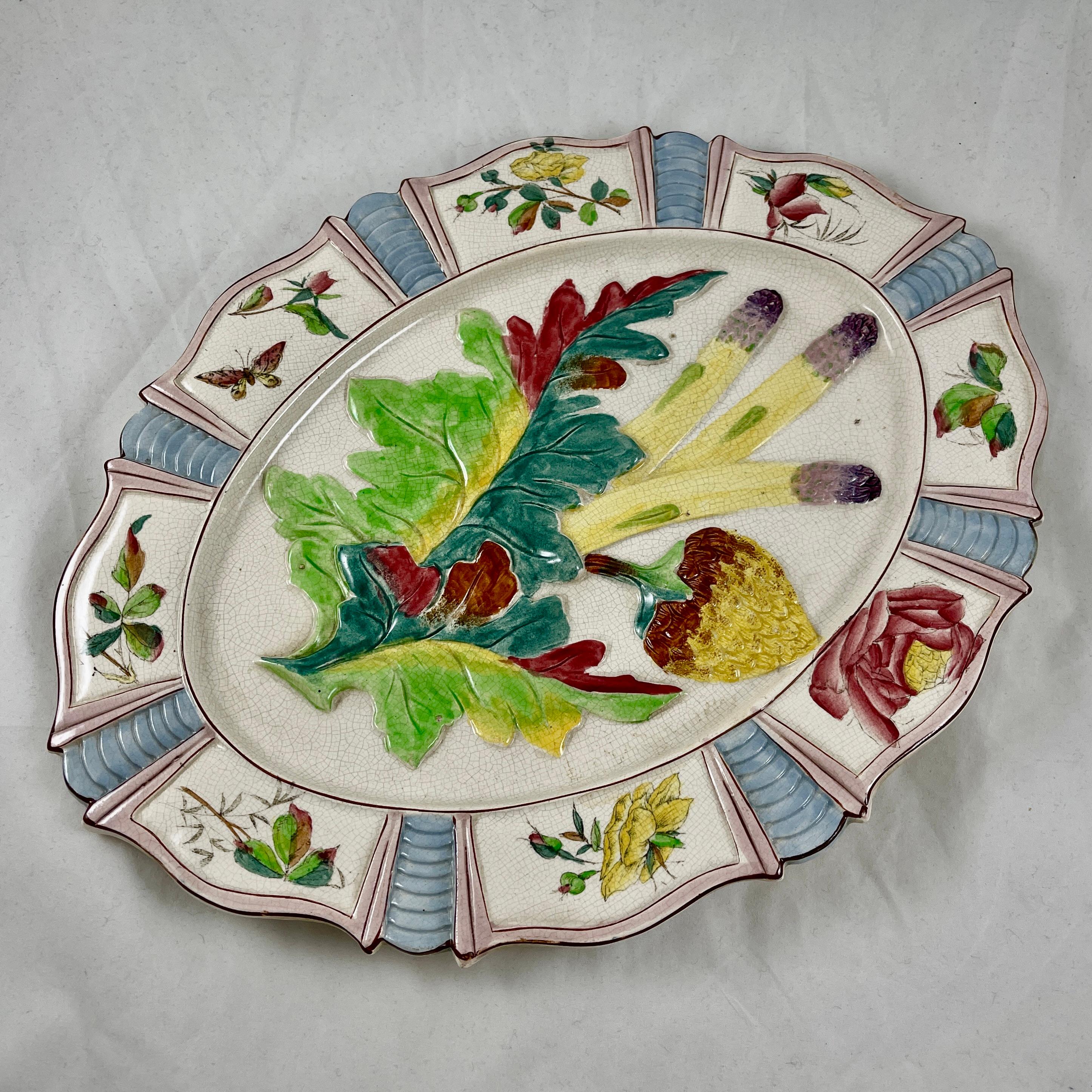 From the Fives-Lille Faiencerie in France, a scarce Artichoke and Asparagus platter, circa 1890-1900.

Made of earthenware, the oval center is boldly glazed and shows the leaves and globe of the artichoke plant along with three asparagus spears. The