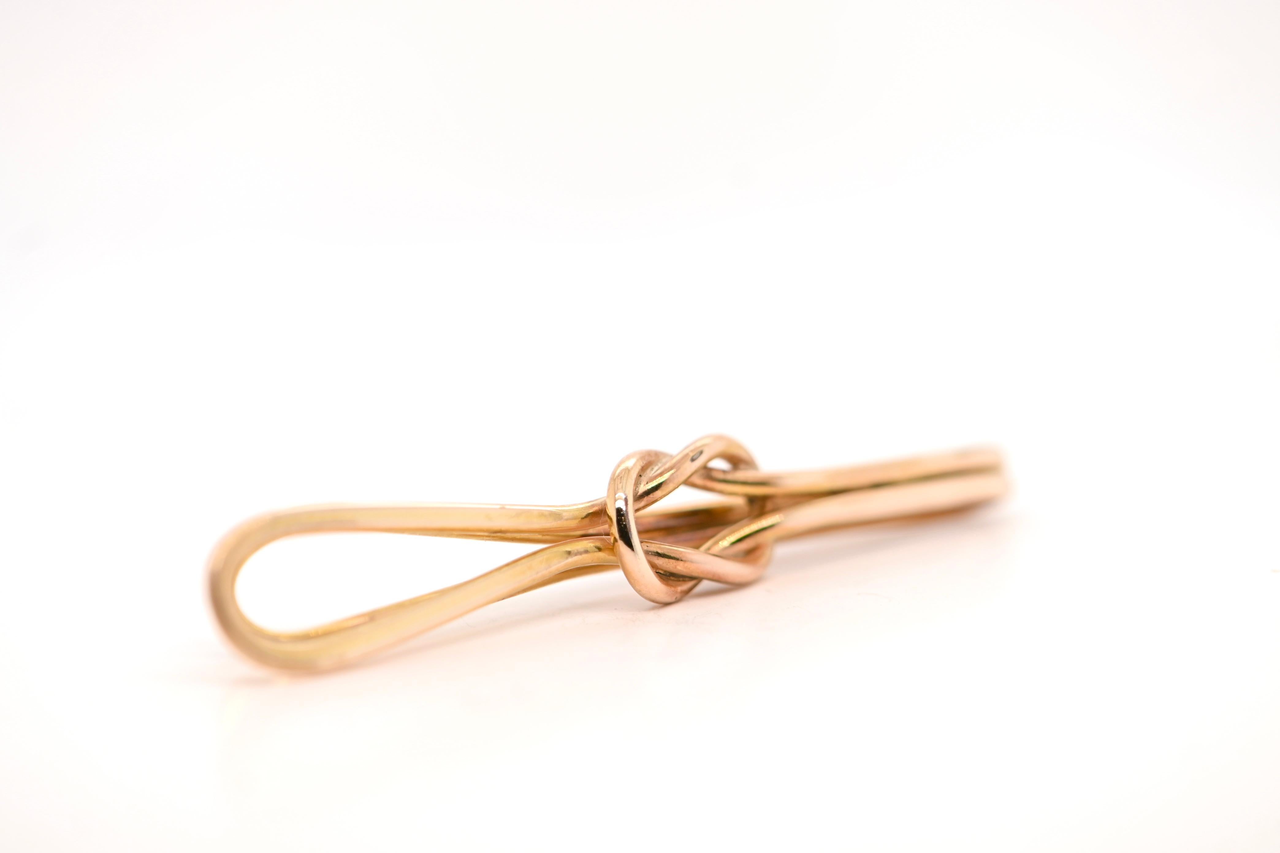 Discover this superb 18-carat pink gold tie-fastener, certified by a poinçon de maître. This refined jewel, in the shape of a figure-of-eight knot, is an elegant accessory for any formal outfit.

With a width of 5.3 cm, a maximum height of 0.8 cm
