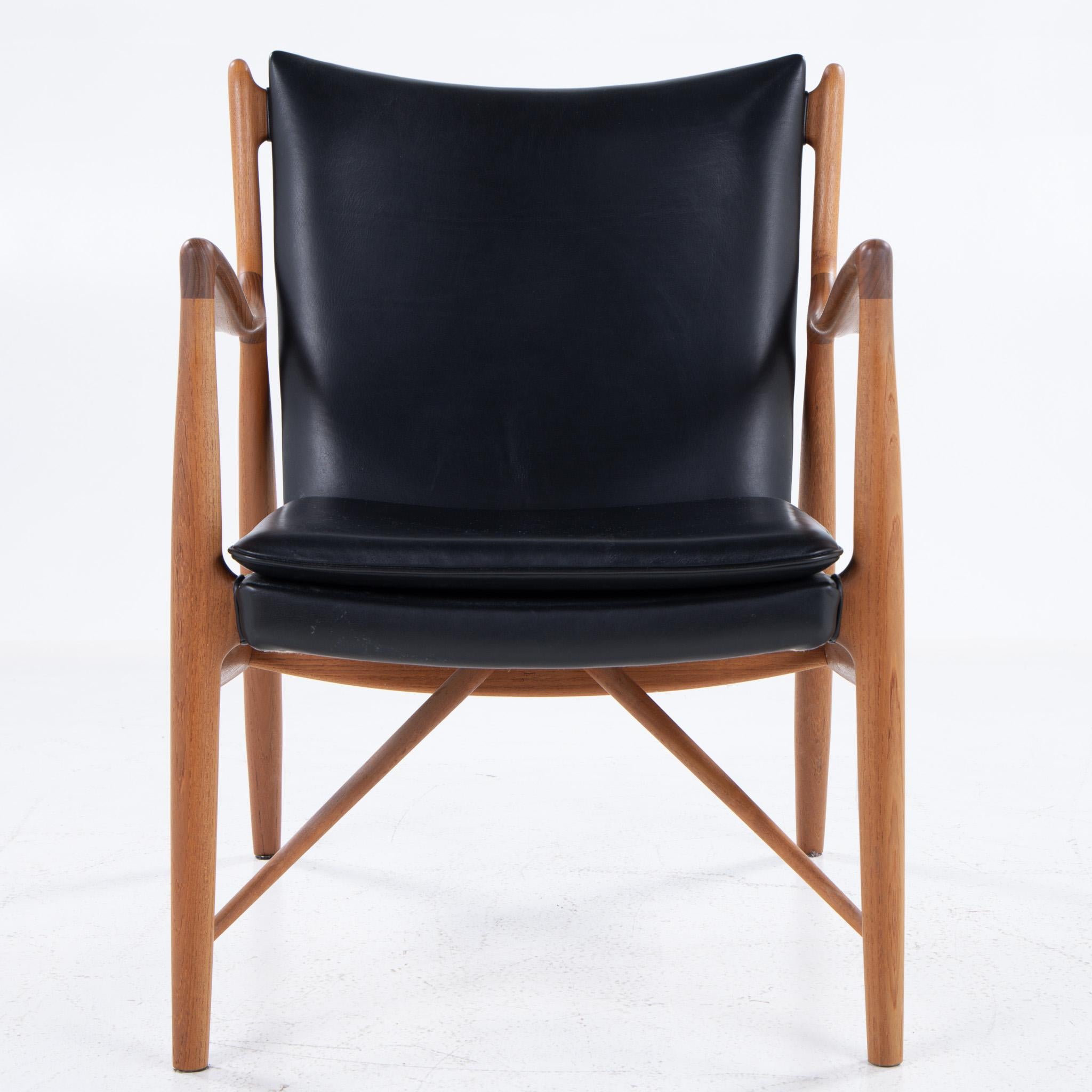 FJ 45 - Easy chair in teak and black leather. Labelled by manufacturer House of Finn Juhl. Designed by Finn Juhl.